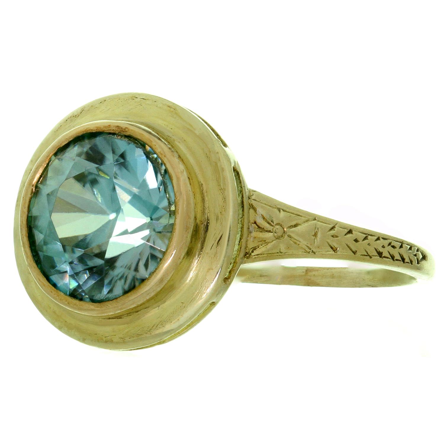This fabulous antique ring features a delicate filigree design hand-crafted in 14k yellow gold and set with a sparkling round diamond-cut blue quartz. Made in United States circa 1950s. Measurements: 0.43