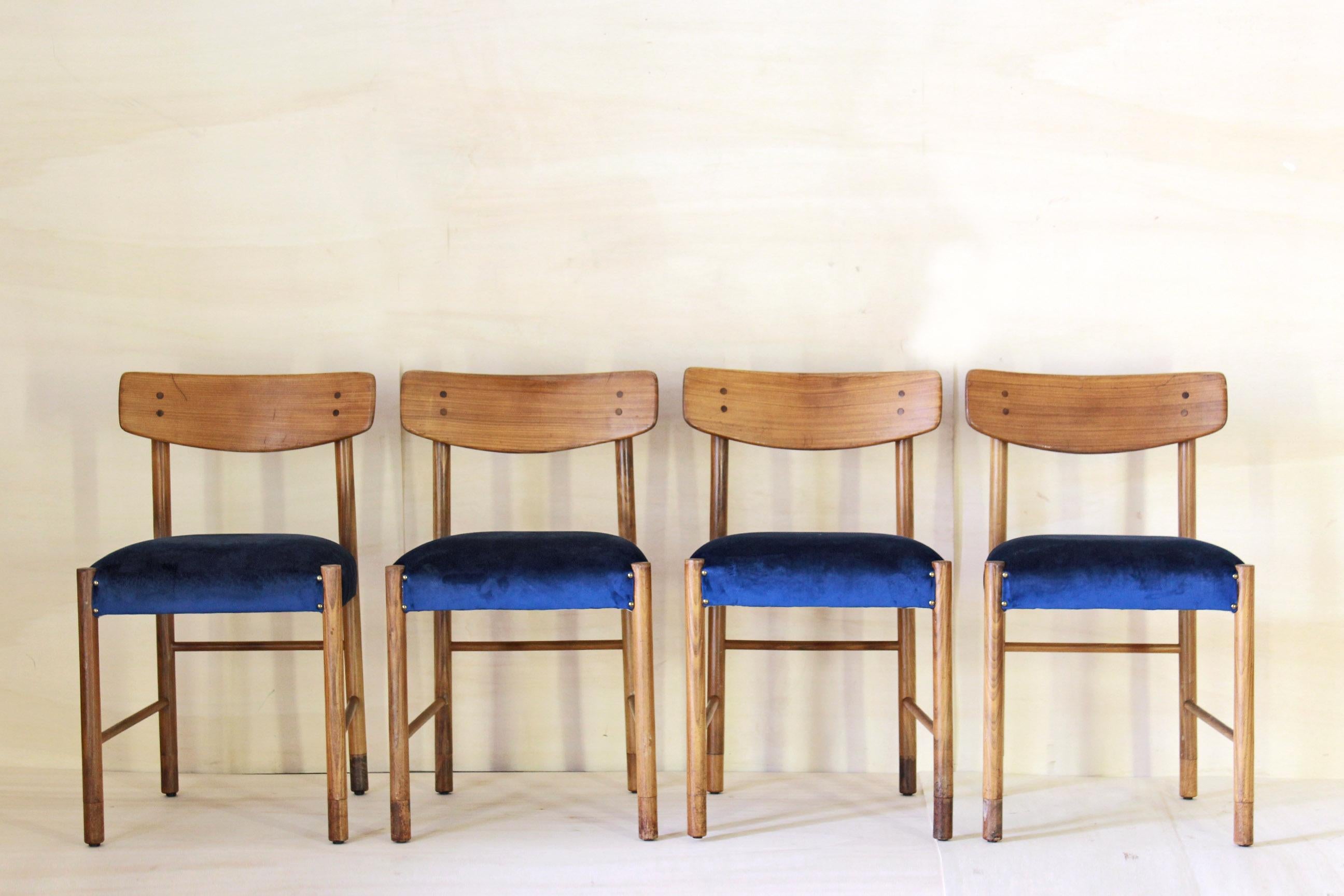 Set of four dining chairs. Blue velvet seats and solid wood structure the set has been completely restored, wood structure has been polished and treated whereas, the seats have been reupholstered, brand new filling and velvet cover. In excellent