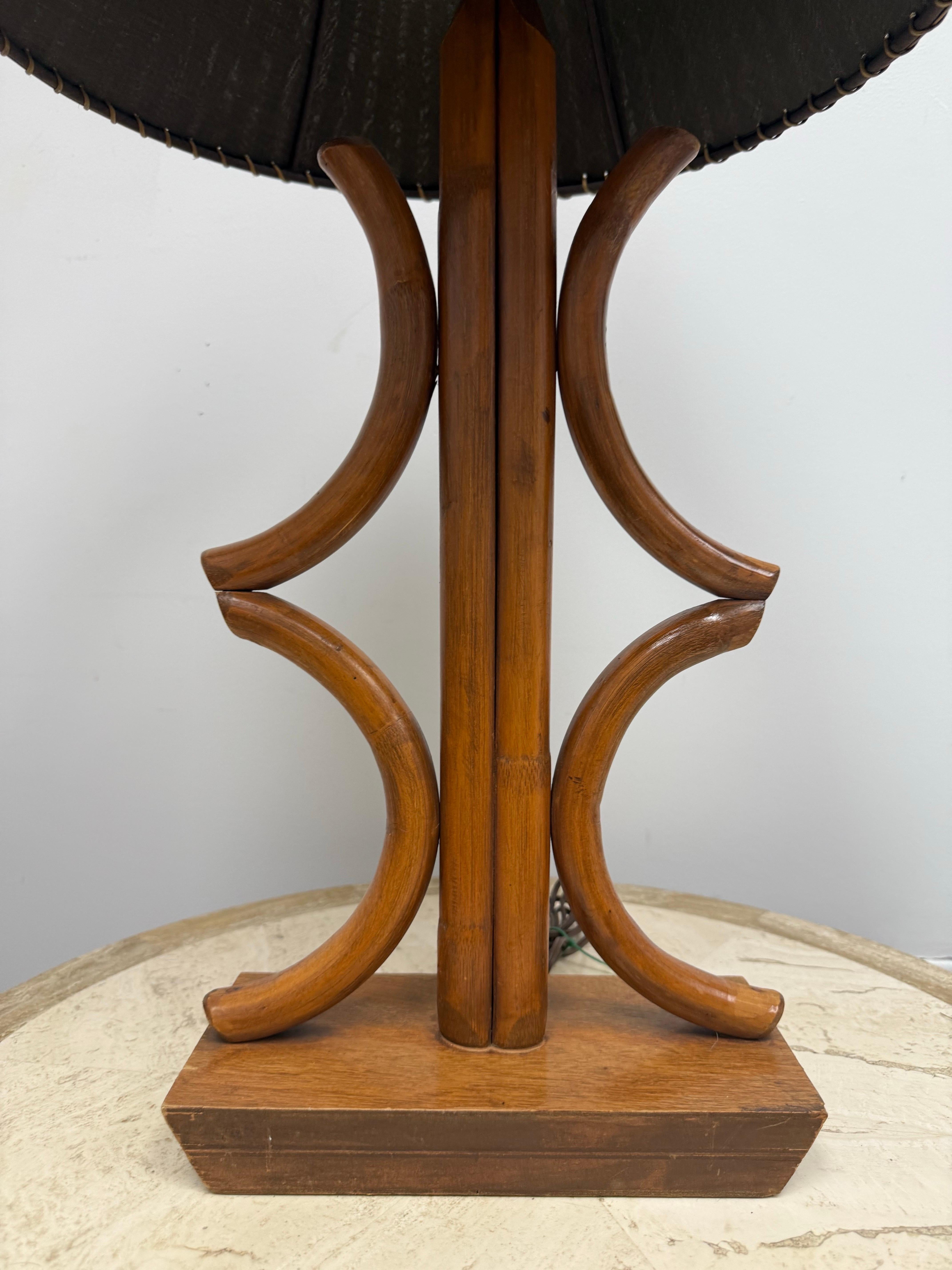 Esta fantástica lámpara de sobremesa es obra de Paul Frankl, hacia 1950.  

Lleva el trópico a tu salón con esta lámpara de mesa de bambú curvado.  Los ricos tonos marrones del bambú arqueado ofrecen una belleza única que sólo la naturaleza puede