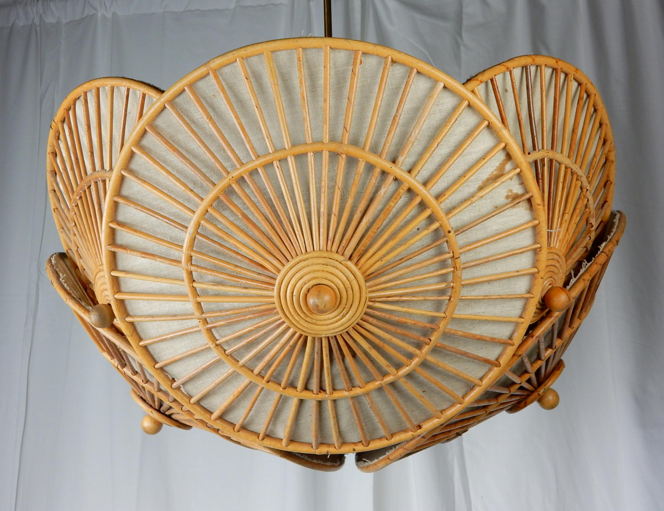 Unique chandelier made of a cluster of 6 rattan parasols (each 18 inches across) surrounding a metal frame with 3 inner light bulb sockets
with one down spot in bottom centre. Each parasol has original cloth lining
30 inch brass down rod. Very