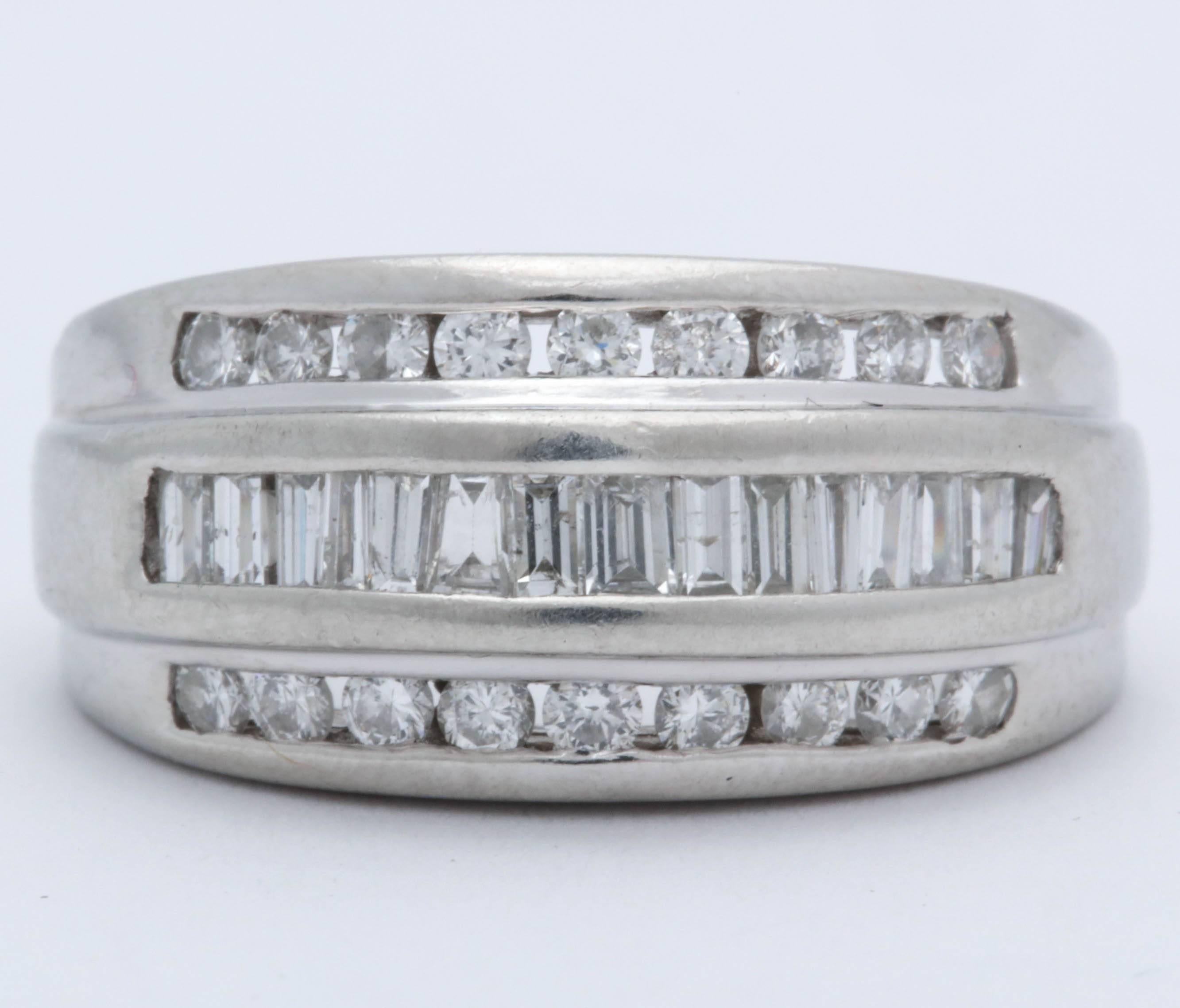 One Platinum Half Way Bombe Style Band Ring Embellished With Numerous Baguette Cut Diamonds In Center Of Ring Weighing Approximately 1.00 Carats Further embellished With Two Rows Of Invisible Set Full Cut diamonds weighing approximately 1 Carat. All