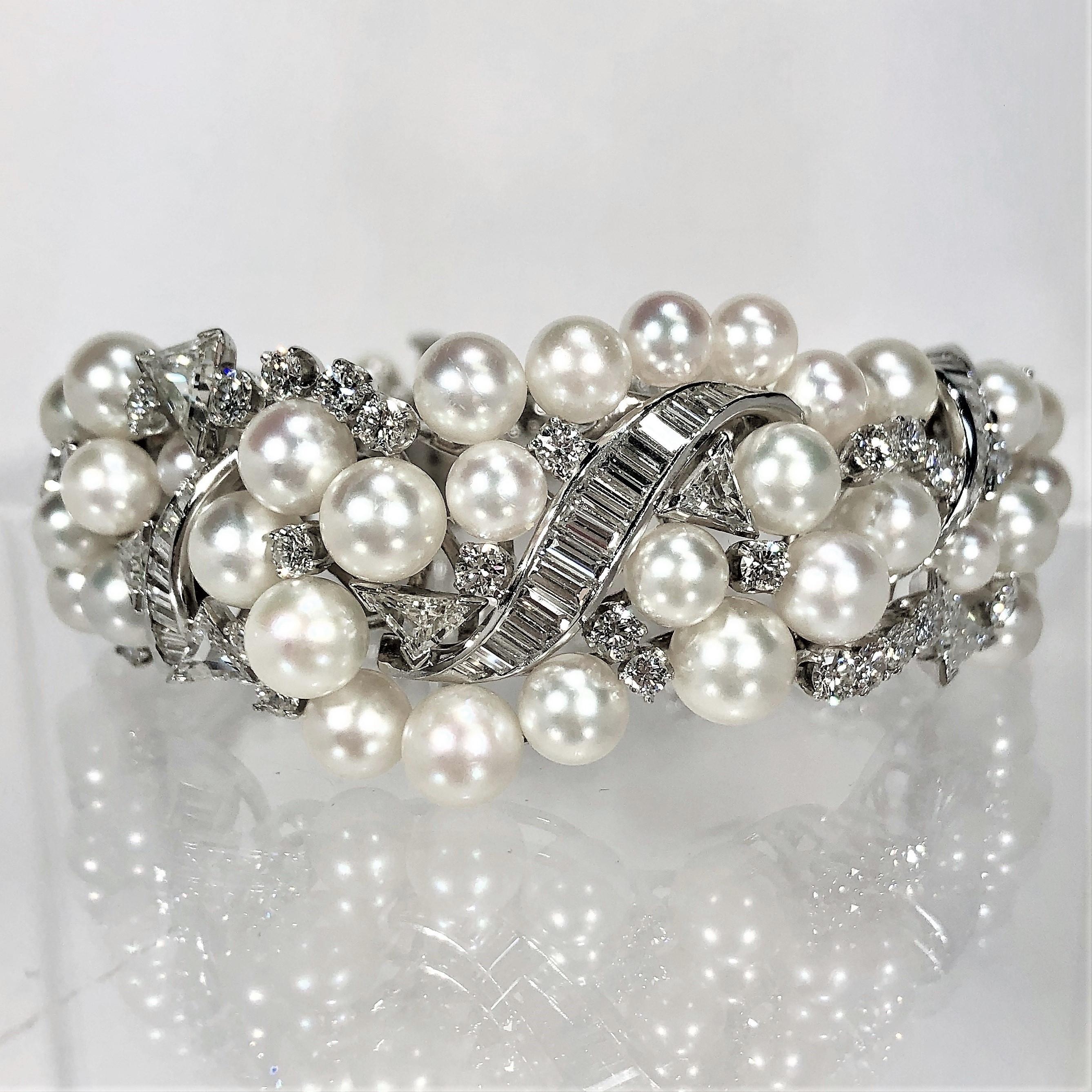 Hand crafted in platinum, this beautiful 1950s bombee pearl and diamond
cocktail bracelet graduates from 1 1/16 inch at the widest point in the front,
down to 9/16 inch wide at the back, by the clasp. The cultured pearls
are very fine quality