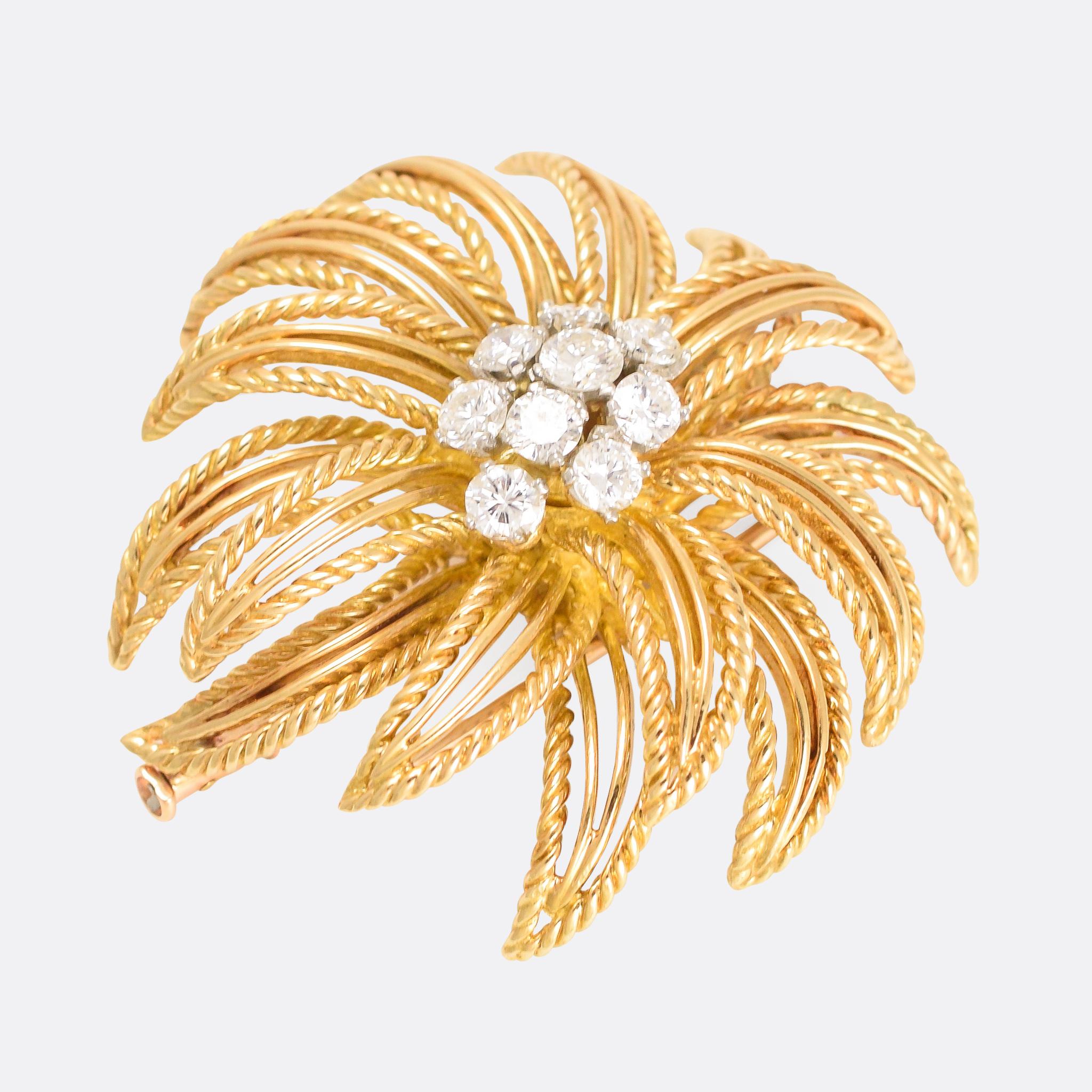 A breathtaking 1950s flower brooch by Boucheron of Paris. The quality throughout is superb, with openworked petals and a central cluster of 9 brilliant cut diamonds (total carat weight 1.55ct). It's crafted in 18k gold, and signed BOUCHERON Made in