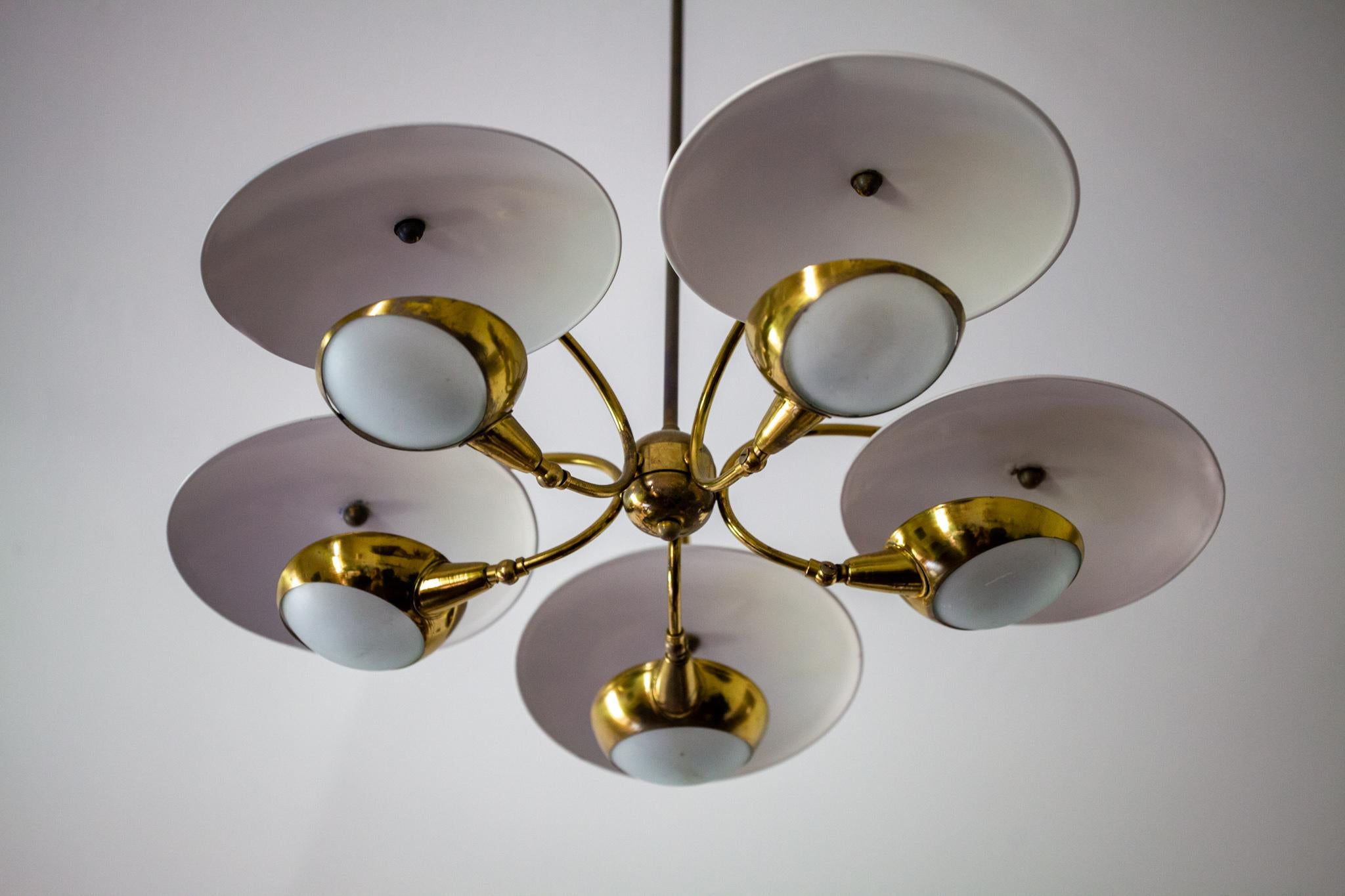 Brass and painted ivory aluminum shades. This whimsical 5-light chandelier is stem mounted. User may cut the stem if a shorter length is desired. Omits a beautiful warm-toned reflective glow from the off-white shades and frosted glass.
