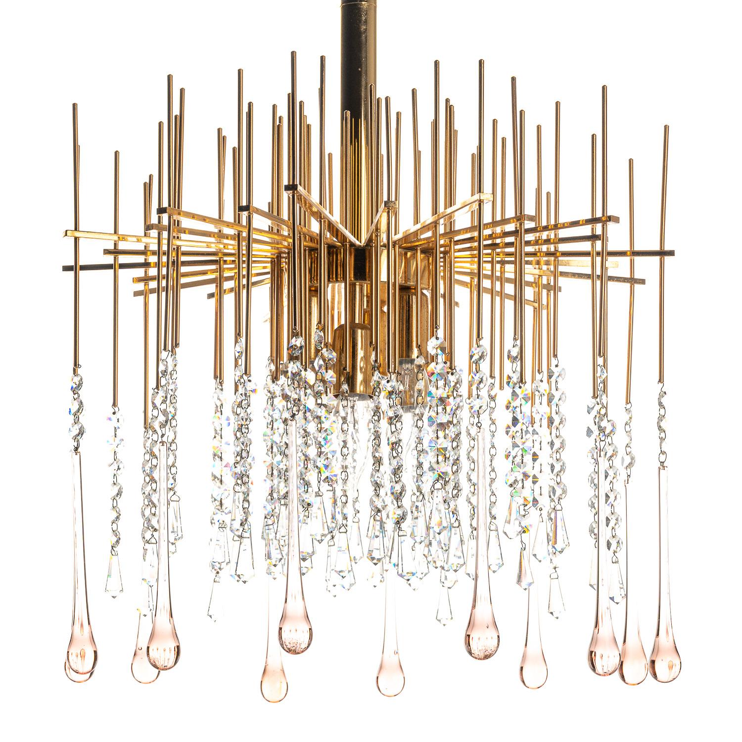 Welcome to this delightful 1950s chandelier, attributed to the designer Palwa. Straight rods radiate vertically and horizontally in a mesmerising form from the brass column, leading to short, pink-tinted crystal drops of various lengths to create a