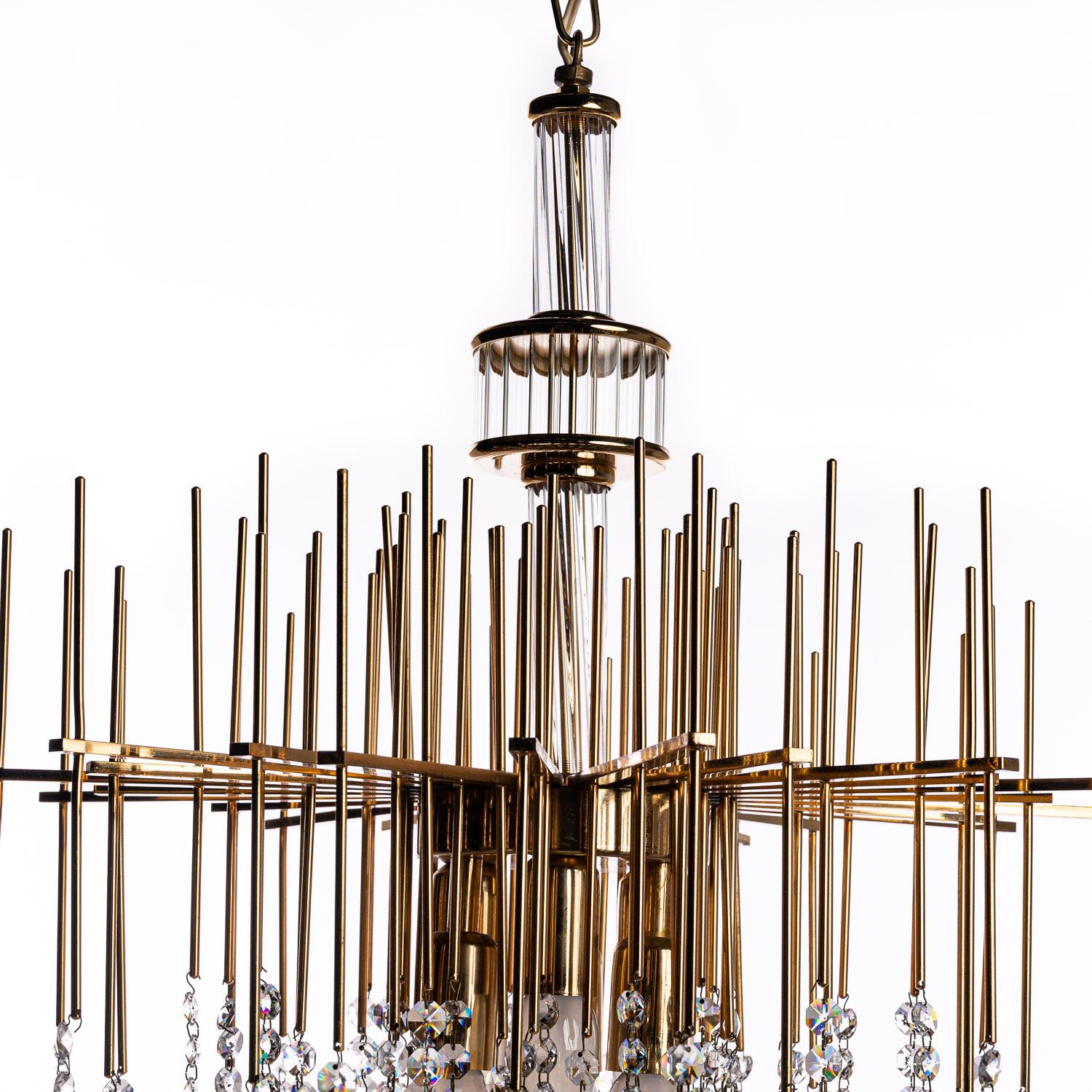 Welcome to this delightful 1950s chandelier, attributed to the designer Palwa. Straight rods radiate vertically and horizontally in a mesmerising form from the brass column, leading to short, light blue-tinted crystal drops to create a stunning