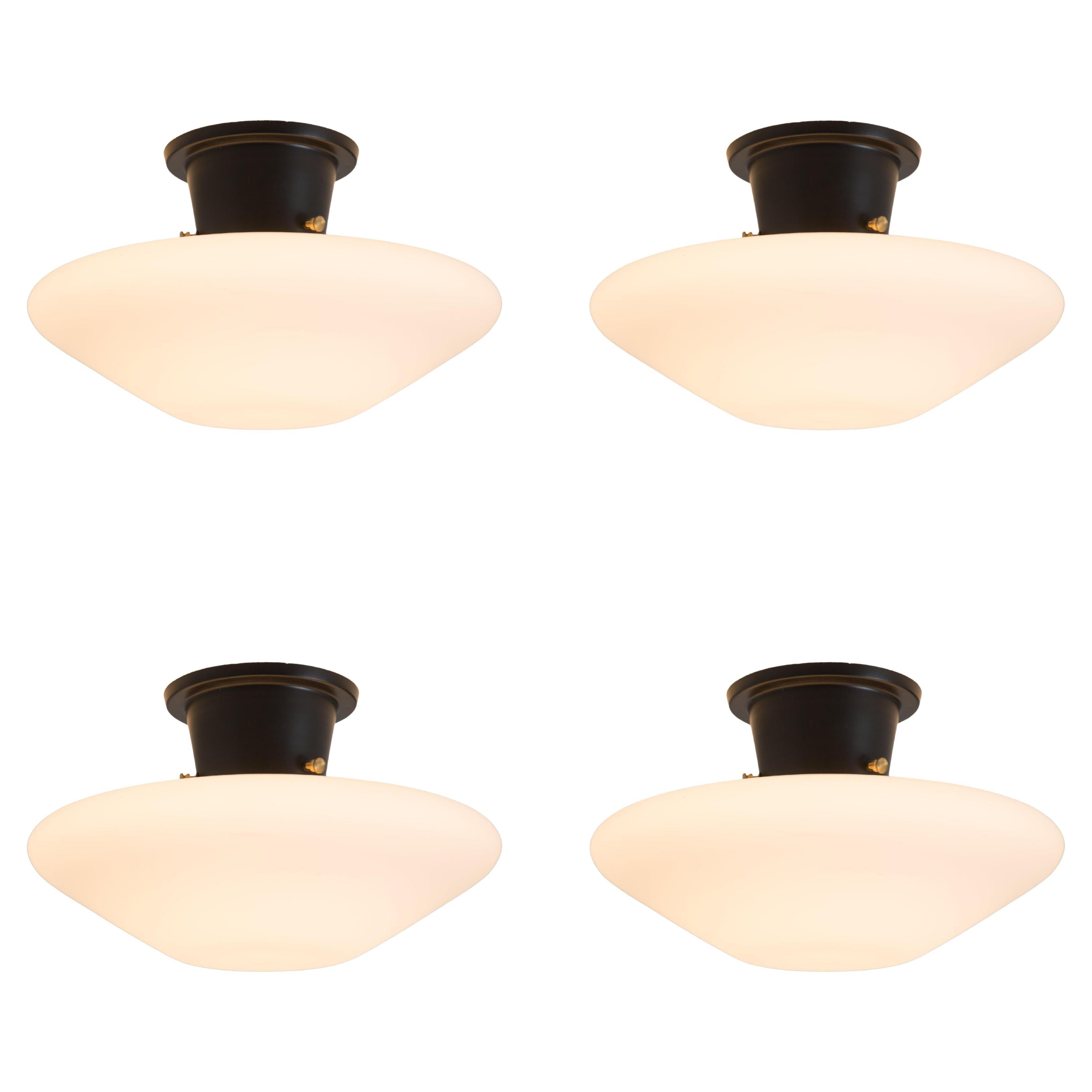 1960s Glass and metal flush mount attributed to Bruno Gatta for Stilnovo. A quintessentially 1950s Italian design executed in textured opaline glass, black painted metal with brass mounting screws. A highly functional and sculptural suspension light
