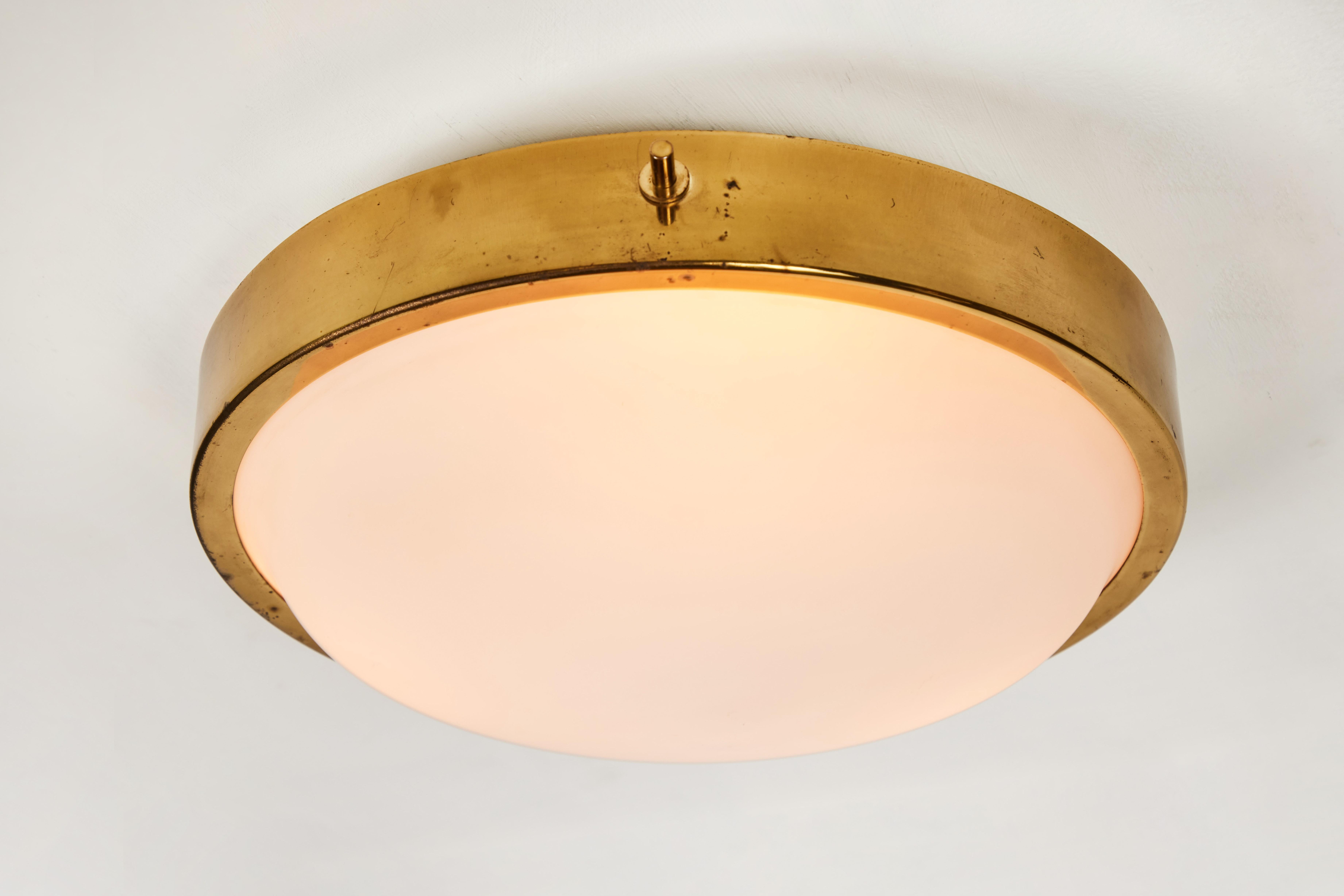 1950s brass and glass ceiling light by Oscar Torlasco for Lumi. Executed in sculpturally curved opaline glass and brass. A highly refined design reminiscent of the work of Bruno Gatta for Stilnovo.

Lumi was one of the most innovative lighting