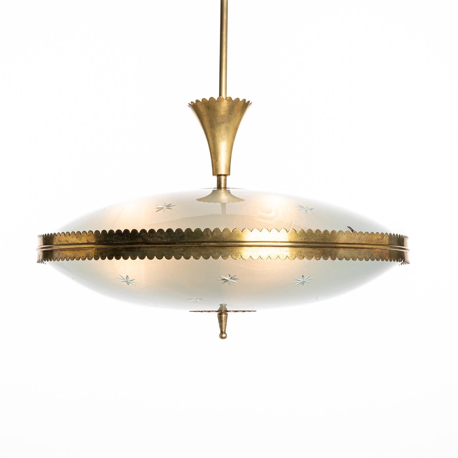 This stunning and elegant light consisting of a brass frame and 2 unique glass reflector/saucers. 
The lower and upper satin and curved glass reflectors with engraved star decorations. A beautiful brass ring to connect the panels. In the center 3