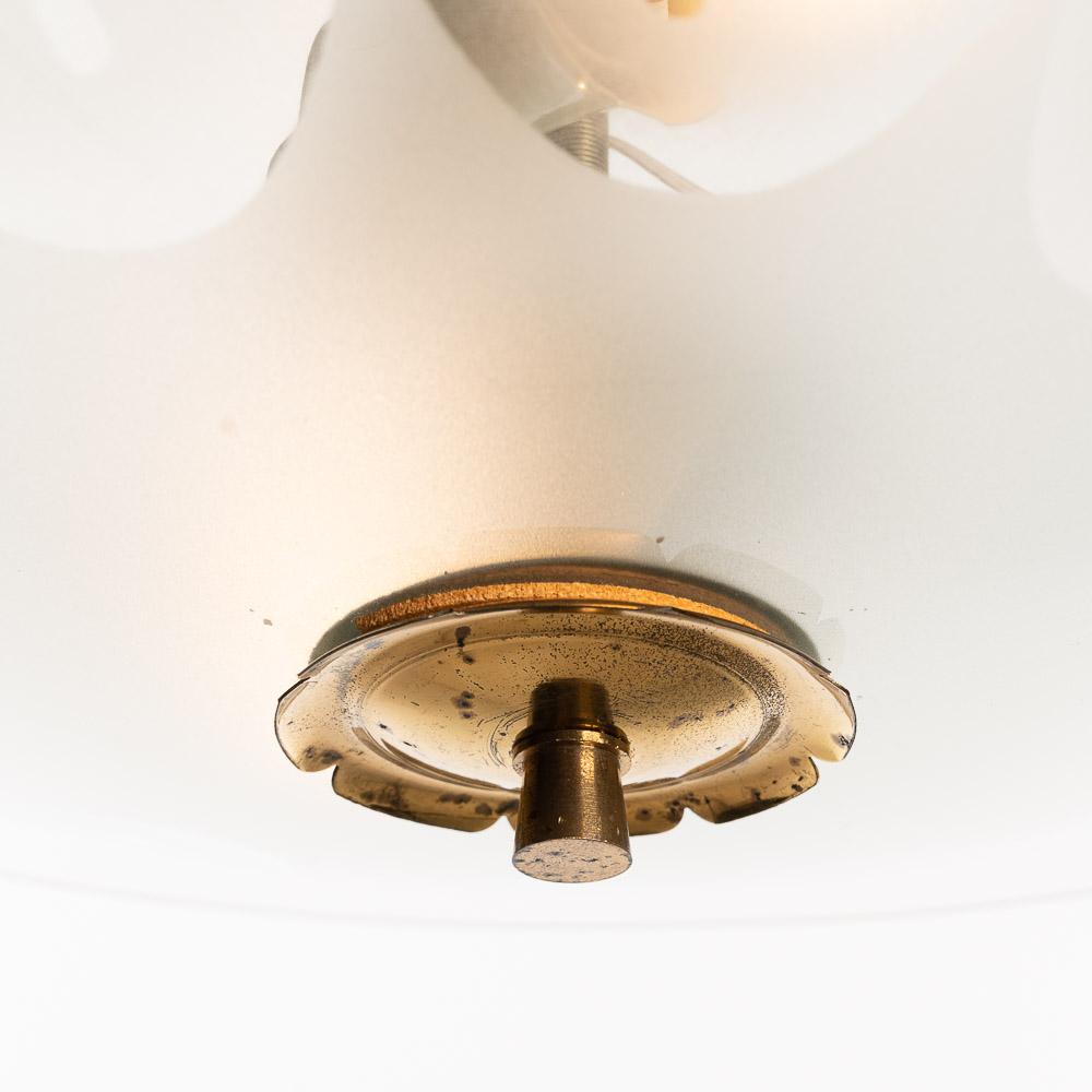 This super elegant light consisting of a brass frame and 2 unique glass reflector/saucers. 
The lower and top round curved glass reflectors both clear glass with flame-like etching. A beautiful brass ring to connect the dishes. In the center two