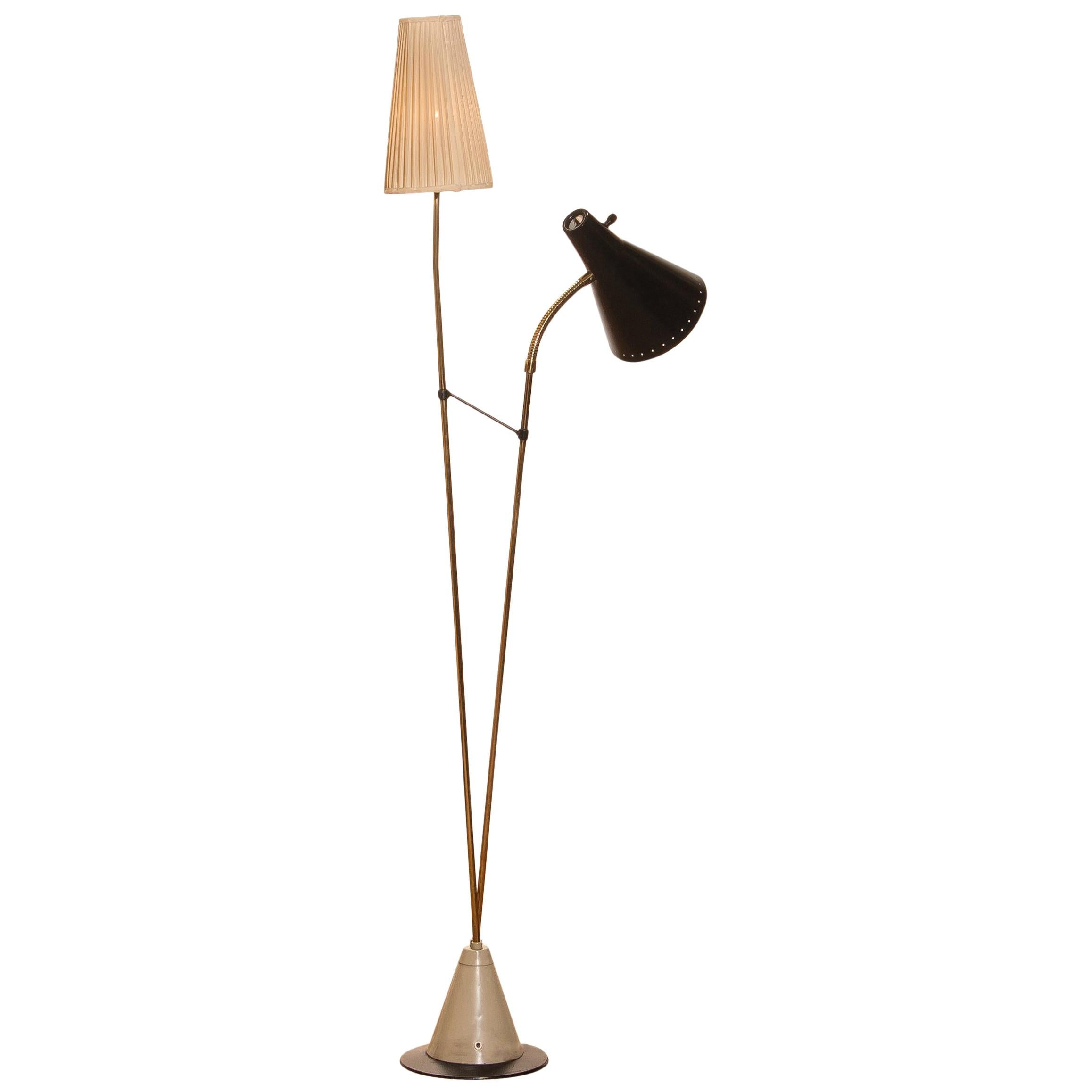 Beautiful floor lamp designed by Hans Bergström for Ateljé Lyktan, Sweden.
This lamp consists of two different shades, one black lacquered metal and one off-white in fabric. The stand is made of brass with a beautiful iron foot. It is in a very