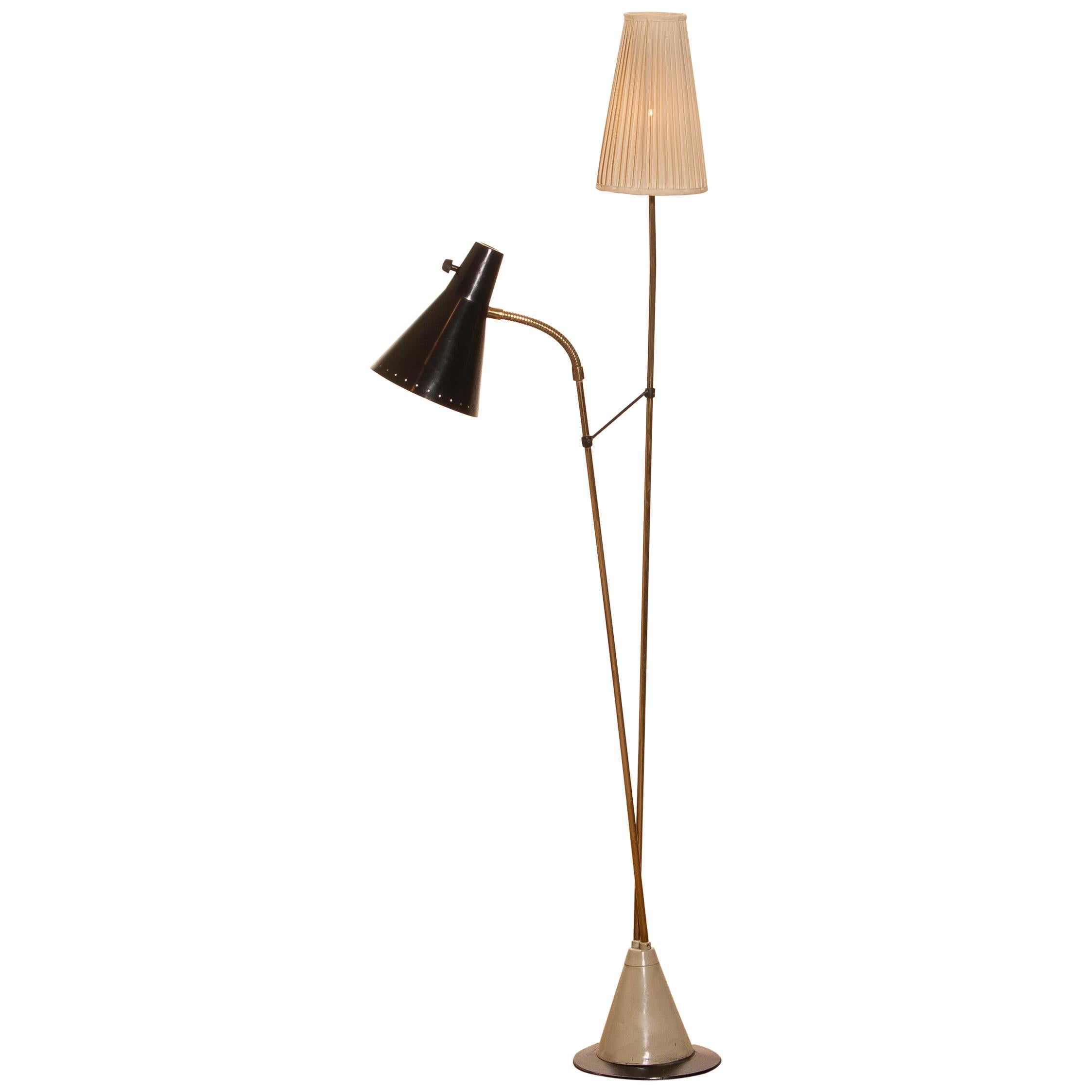 Beautiful floor lamp designed by Hans Bergström for Ateljé Lyktan, Sweden.
This lamp consists of two different shades, one black lacquered metal and one off-white in fabric. The stand is made of brass with a beautiful iron foot. It is in a very