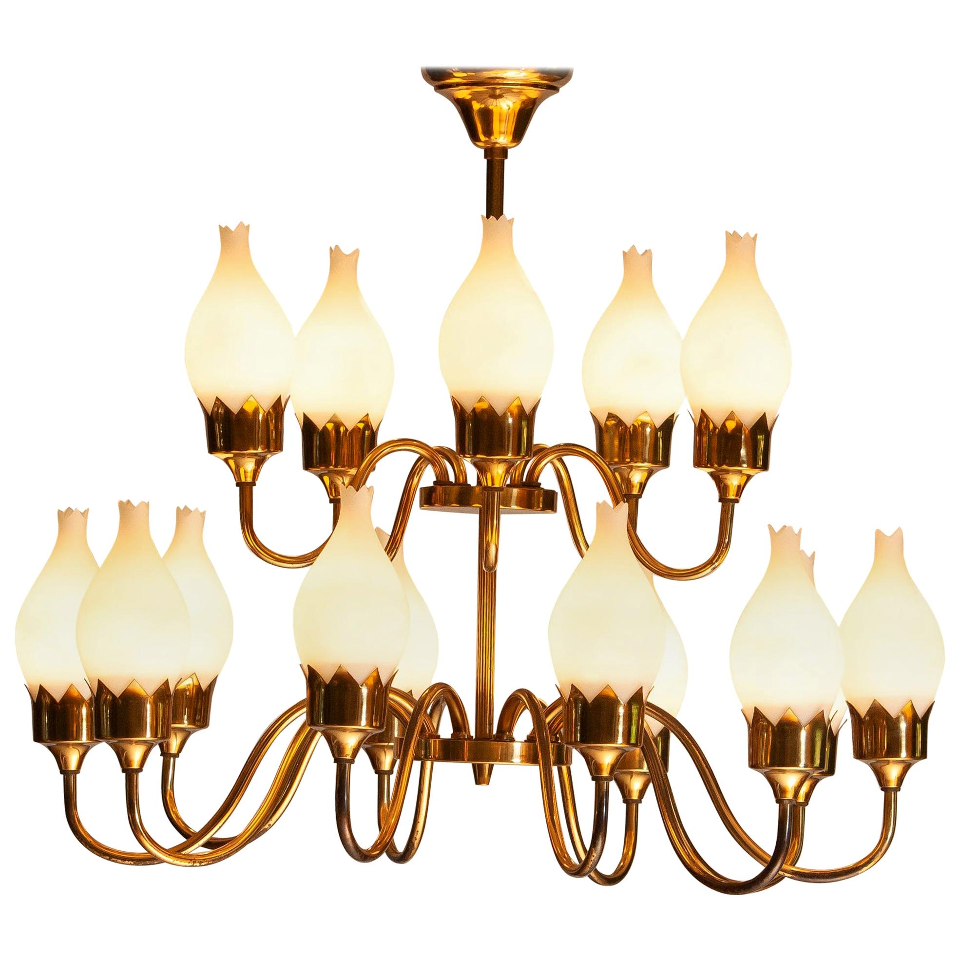 Beautiful gold colored / brass arm chandelier with fifteen arms and white glass / opaline tulips all in original condition by Fog & Mørup, Denmark, 1950s.
Technically 100% with fifteen e27 / E28 sockets which suits 110 and 230 volts.
The overall