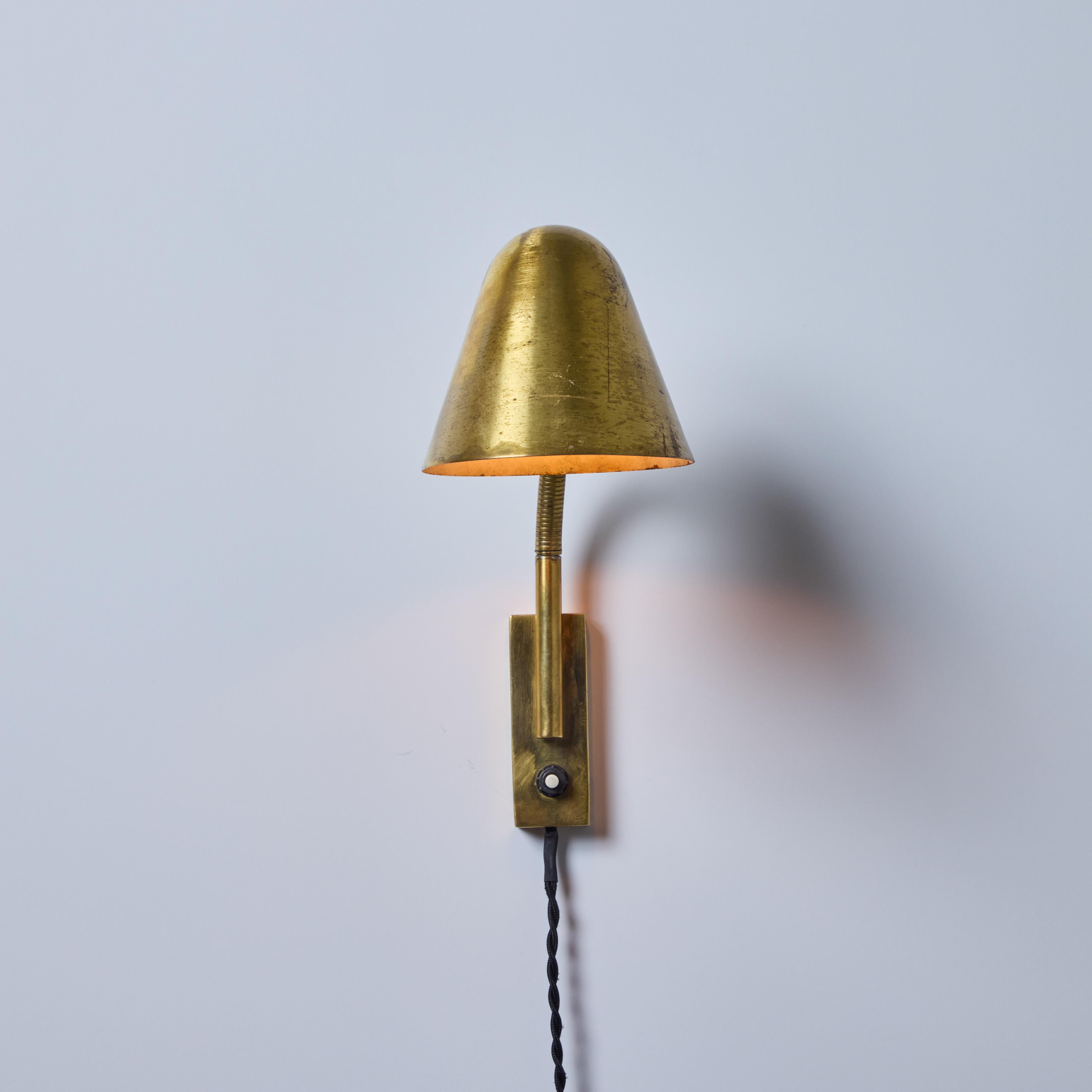 1950s Jacques Biny Brass Articulating Wall Lamp

An exceptionally clean and simple plug-in wall lamp design executed in patinated brass with white painted inner shade. Shade can be moved on goosneck arm. On/off switch on lamp base. Quintessentially