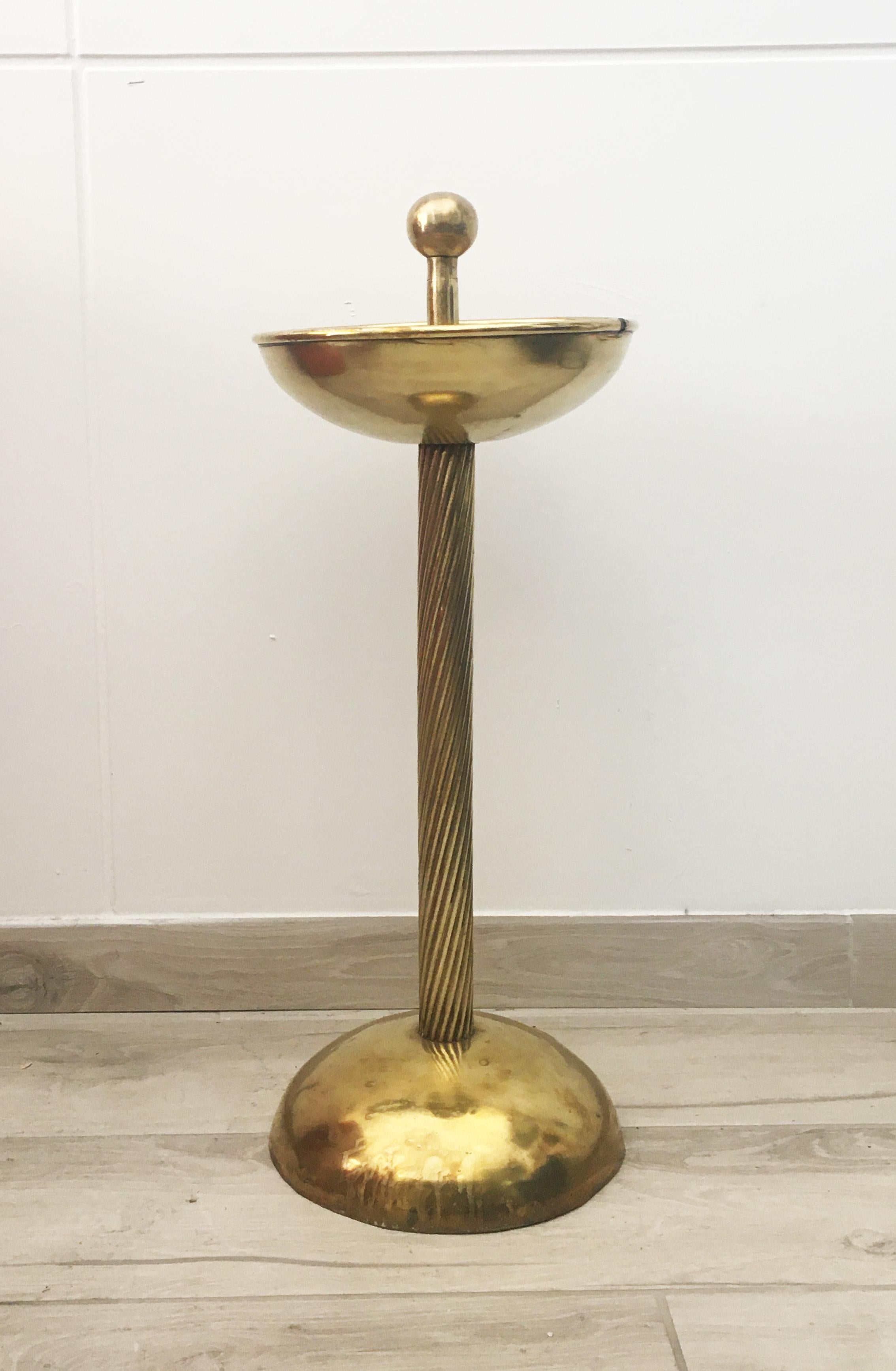 This floor ashtray was made in Italy in the 1950s. It is made of polished brass with a twisted stem.