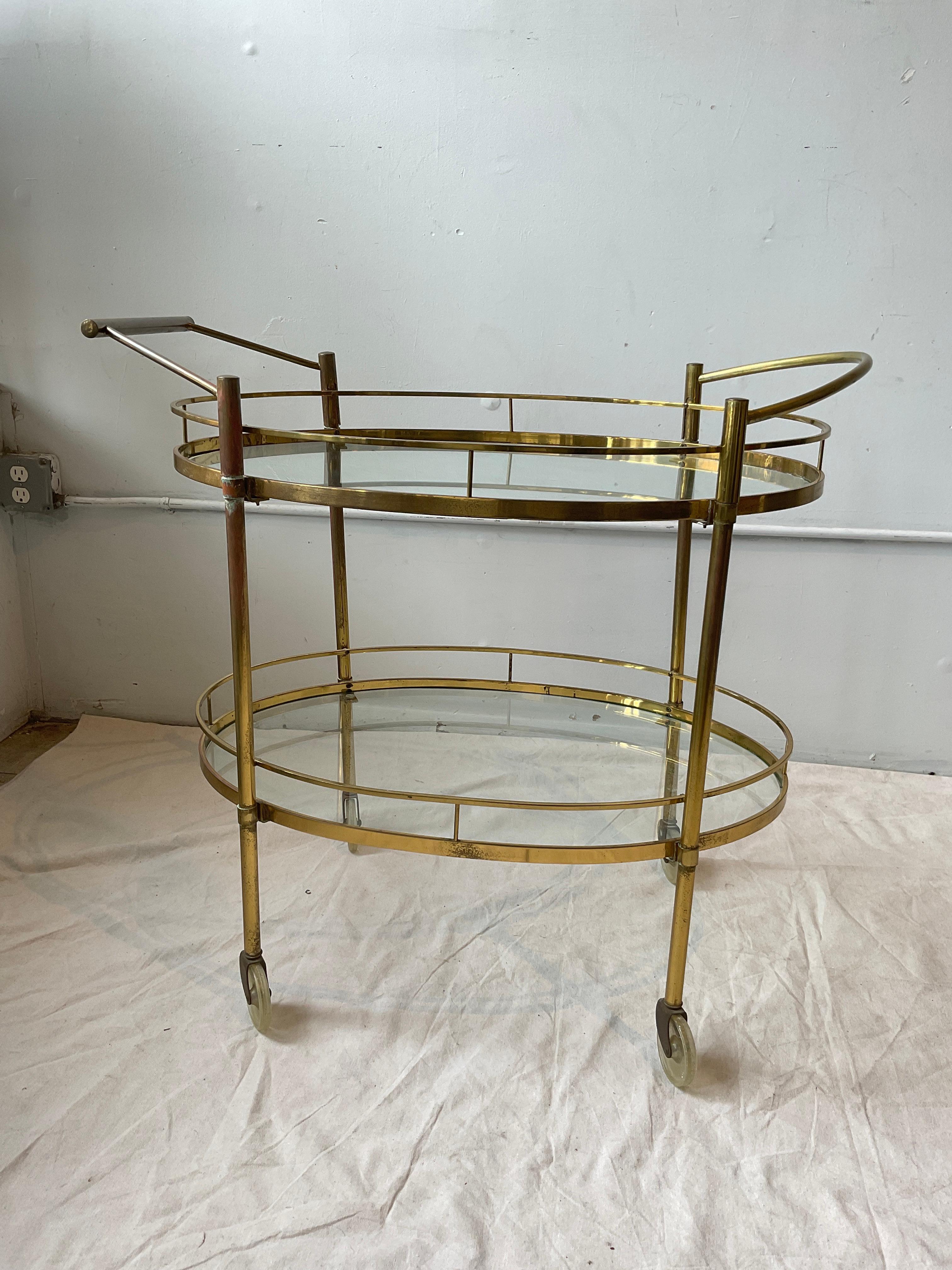 1950s Brass bar cart. Wear to areas in brass. Chips in one piece of glass.