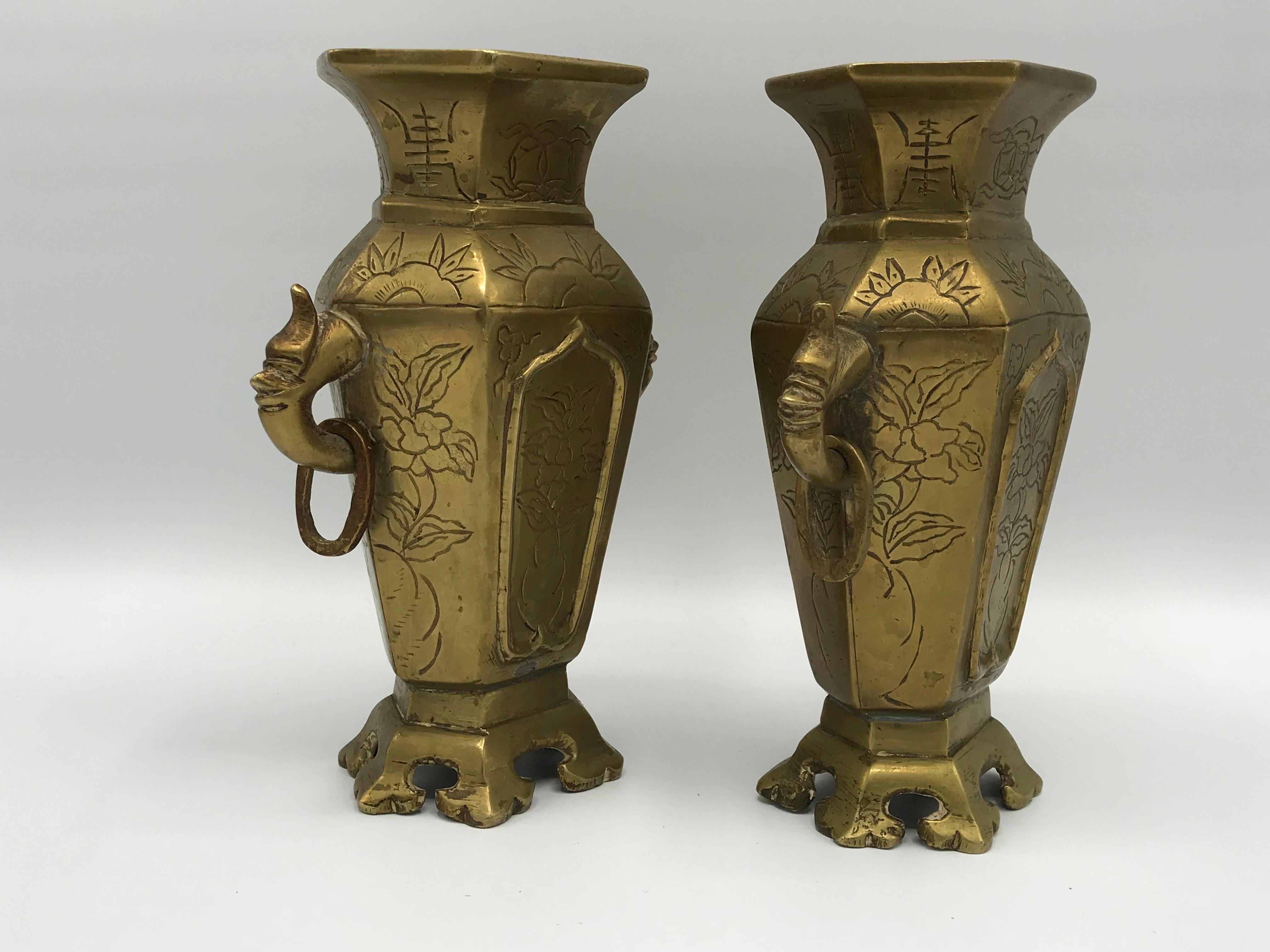 Offered is a stunning, pair of 1950s brass chinoiserie censor vases. The pair stands 7.75in tall on their ornate footing. Fabulous ornate floral motif and patina all-over. One censor is missing a ring on the side, please see photos 4, 5, 9, and 10.