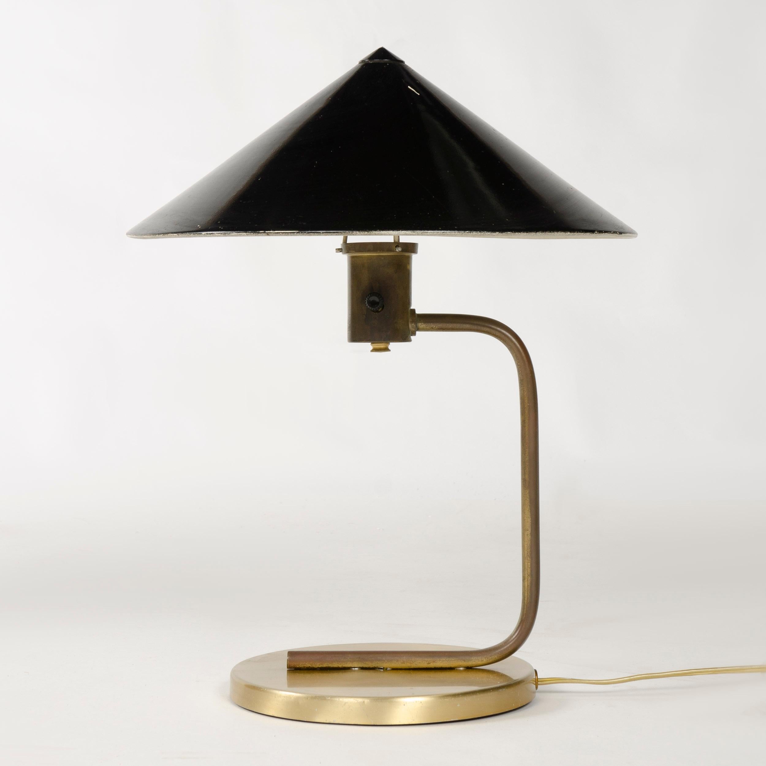 A brass and steel desk lamp with a conical spun aluminum black enameled shade.