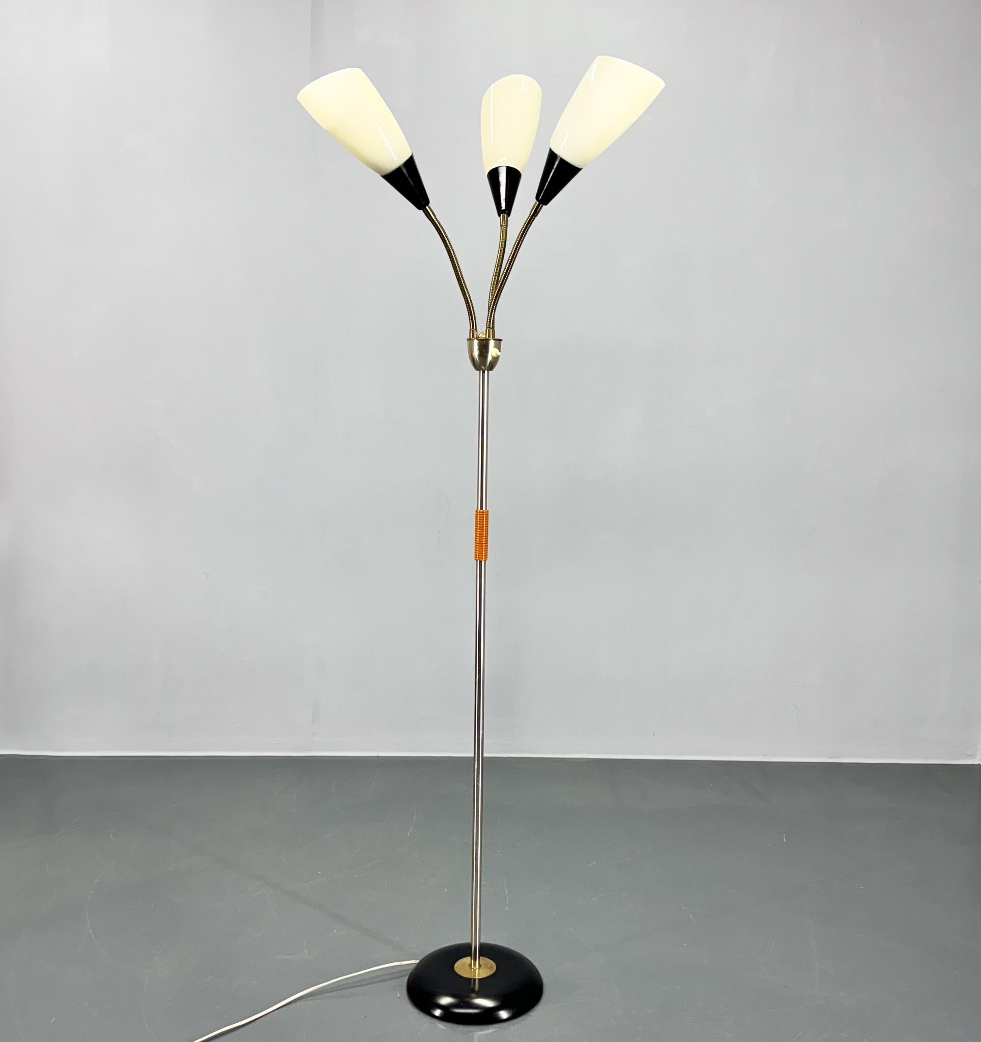 Vintage floor lamp from the 1950's, made of brass, metal and opaline glass with wooden detail. The lamp has two circuits, it can shine either one, two or all three lights. Produced in Germany in the middle of 20th century. 
US adapter included.
