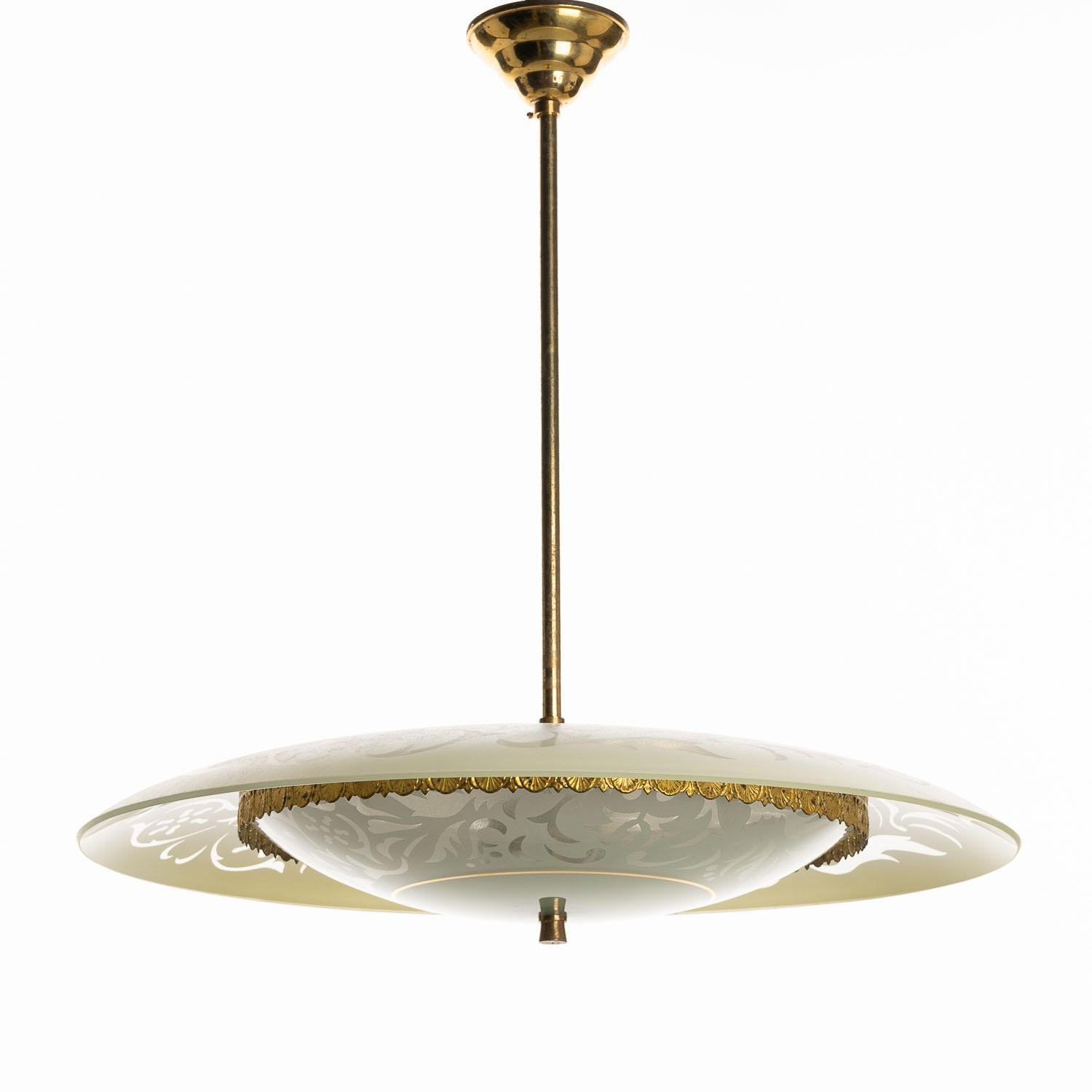 With a nod to the style of Pietro Chiesa, this mid-century brass and glass pendant lighting is a great way to illuminate your space with style. The patterned glass plate sits atop the decorative brass-edged plate underneath, resulting in a stunning