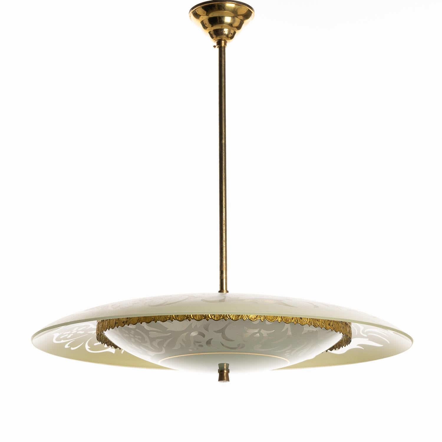 Un clin d'œil au style de Pietro Chiesa, ce luminaire suspendu en laiton et en verre du milieu du siècle dernier est une excellente façon d'éclairer votre espace avec style. L'assiette en verre à motifs repose sur l'assiette décorative à bordures en