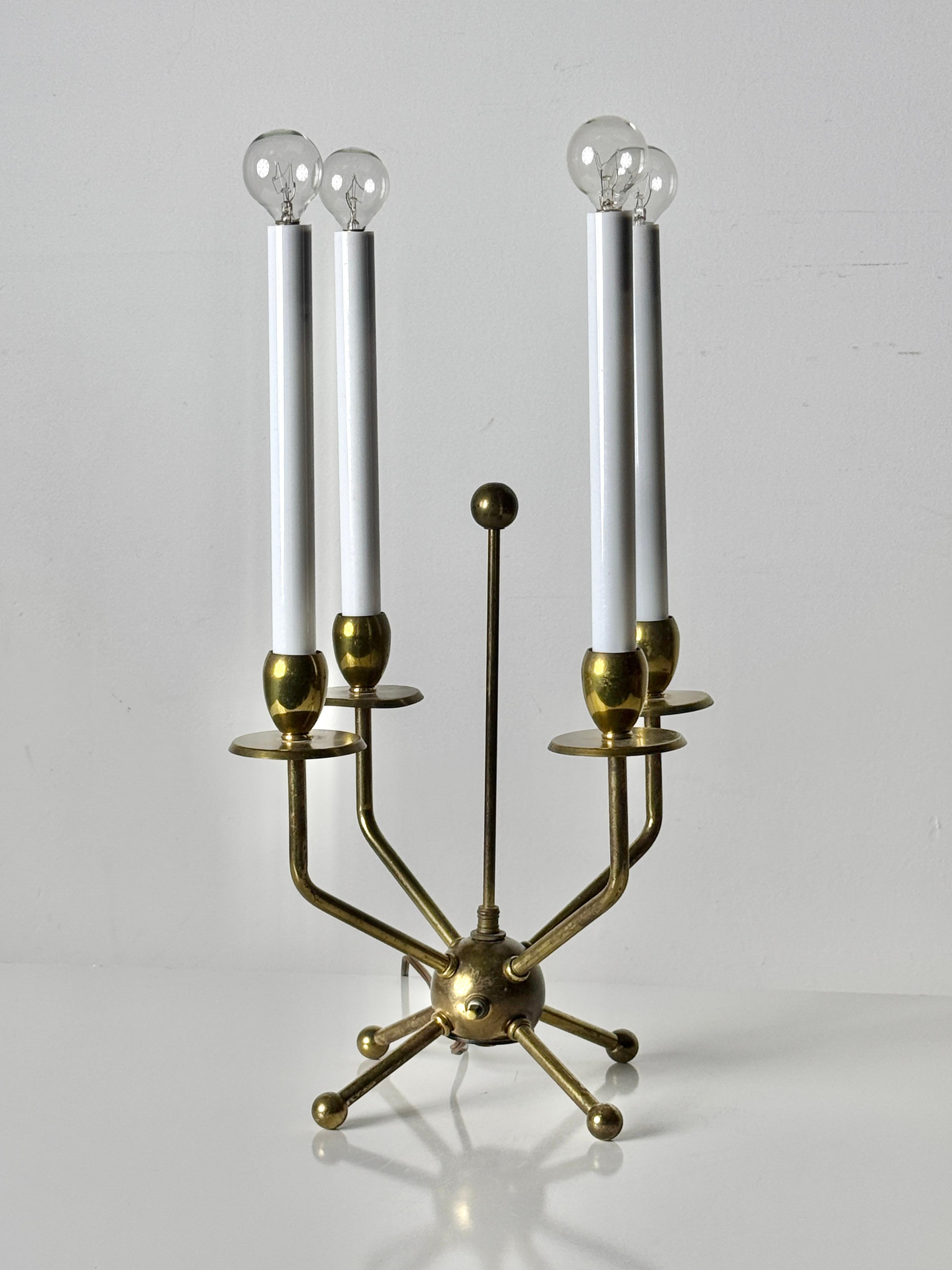 Mid Century Modern candelabra table lamp in the style of Tommi Parzinger circa 1950's

Elegant modernist design with brass sputnik base and four extending arms holding tall white candle style lights

12 inch diameter
20 inch height