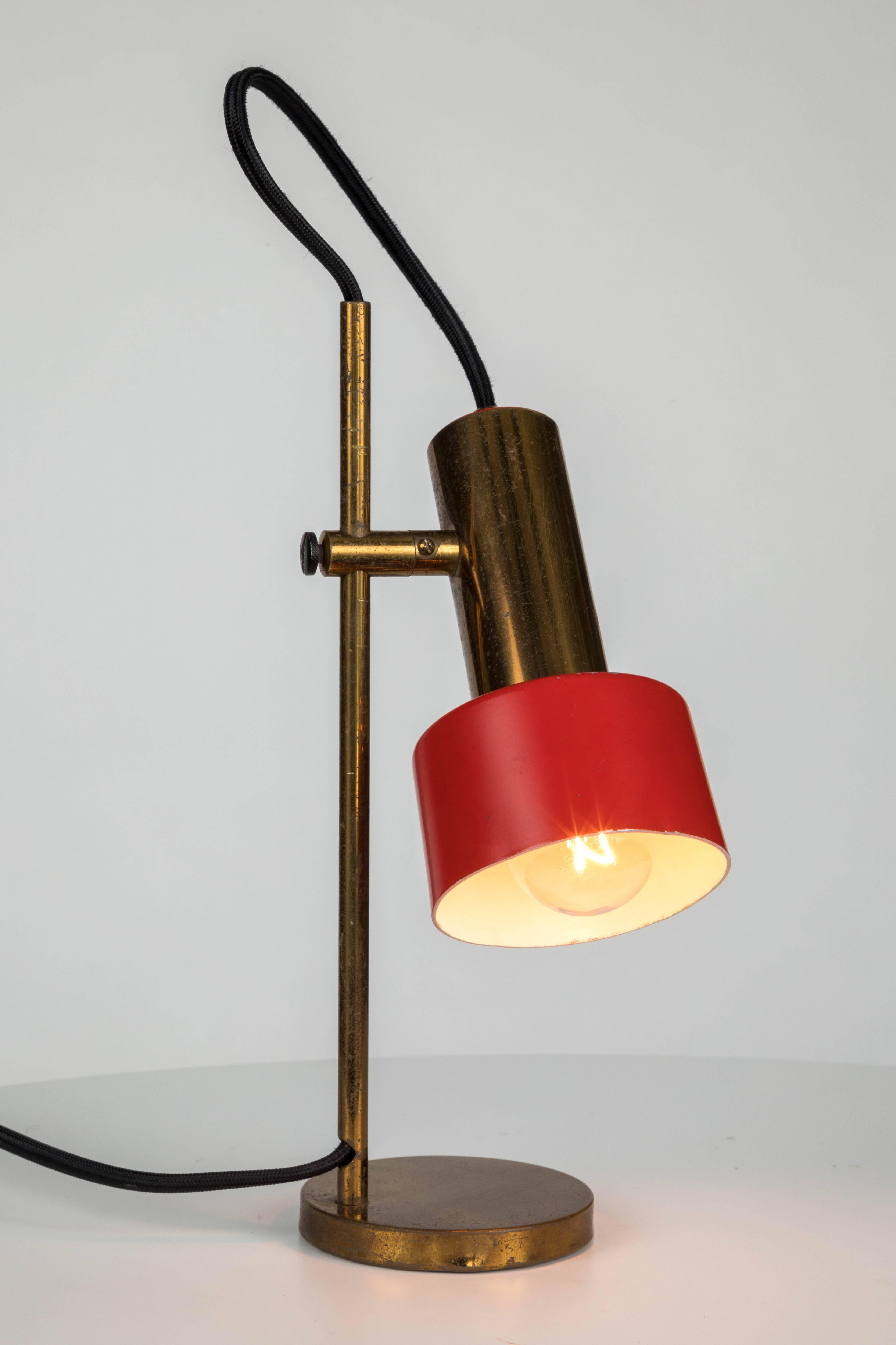 1950s brass table lamp by Casey Fantin. This petite classic design is executed in lightly patinated brass and red painted metal with original color in good vintage condition. Shade can rotate from side to side and be moved up or down.

Fantin was