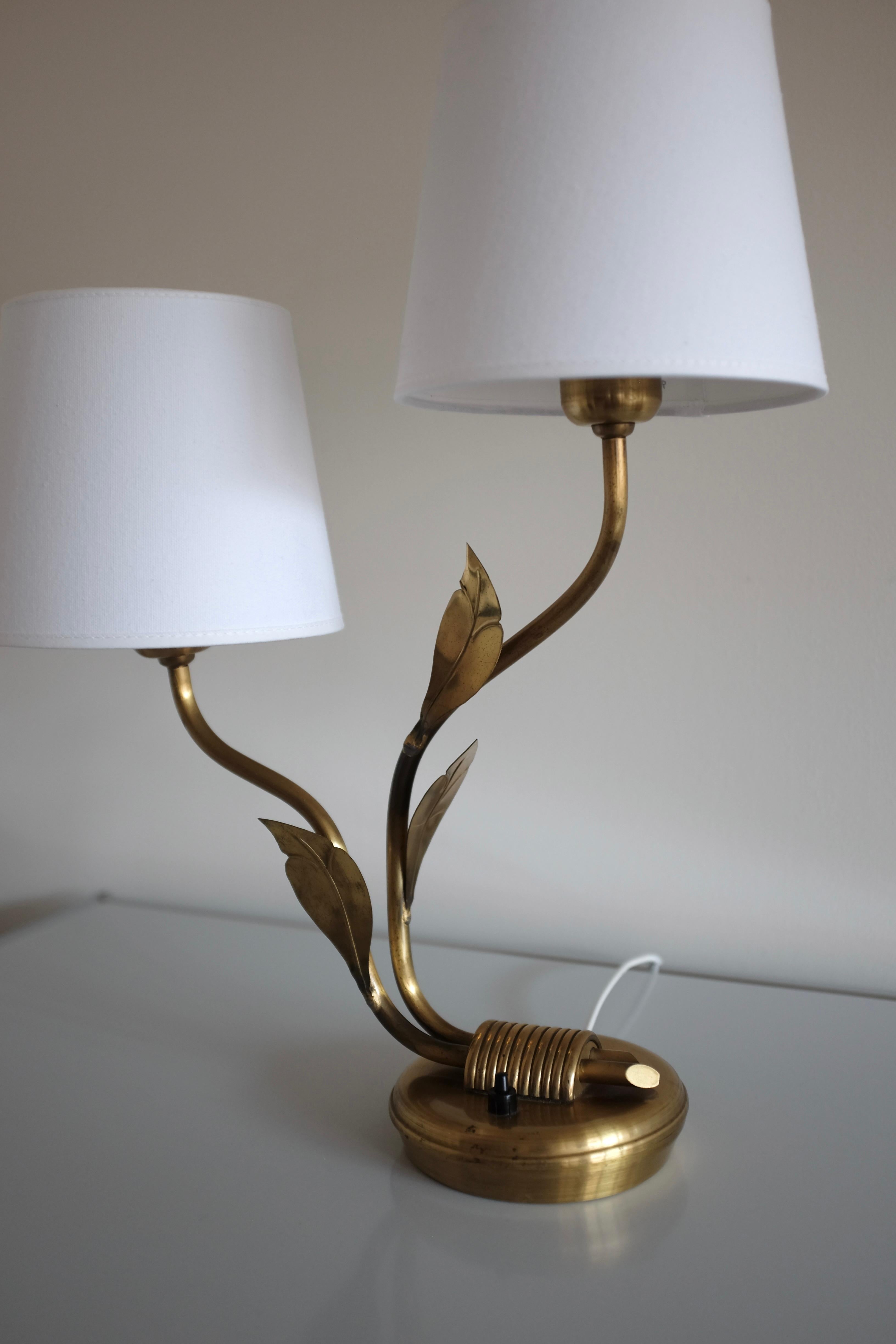 Beautiful organic brass table lamp by Edvard Hagman AB, Sweden. From around the 1950s it has 3 beautiful brass leaf ornaments that decorates the 2 lamp arms. White lamp shades that clips on to the light bulbs. Marked with the manufactures initials