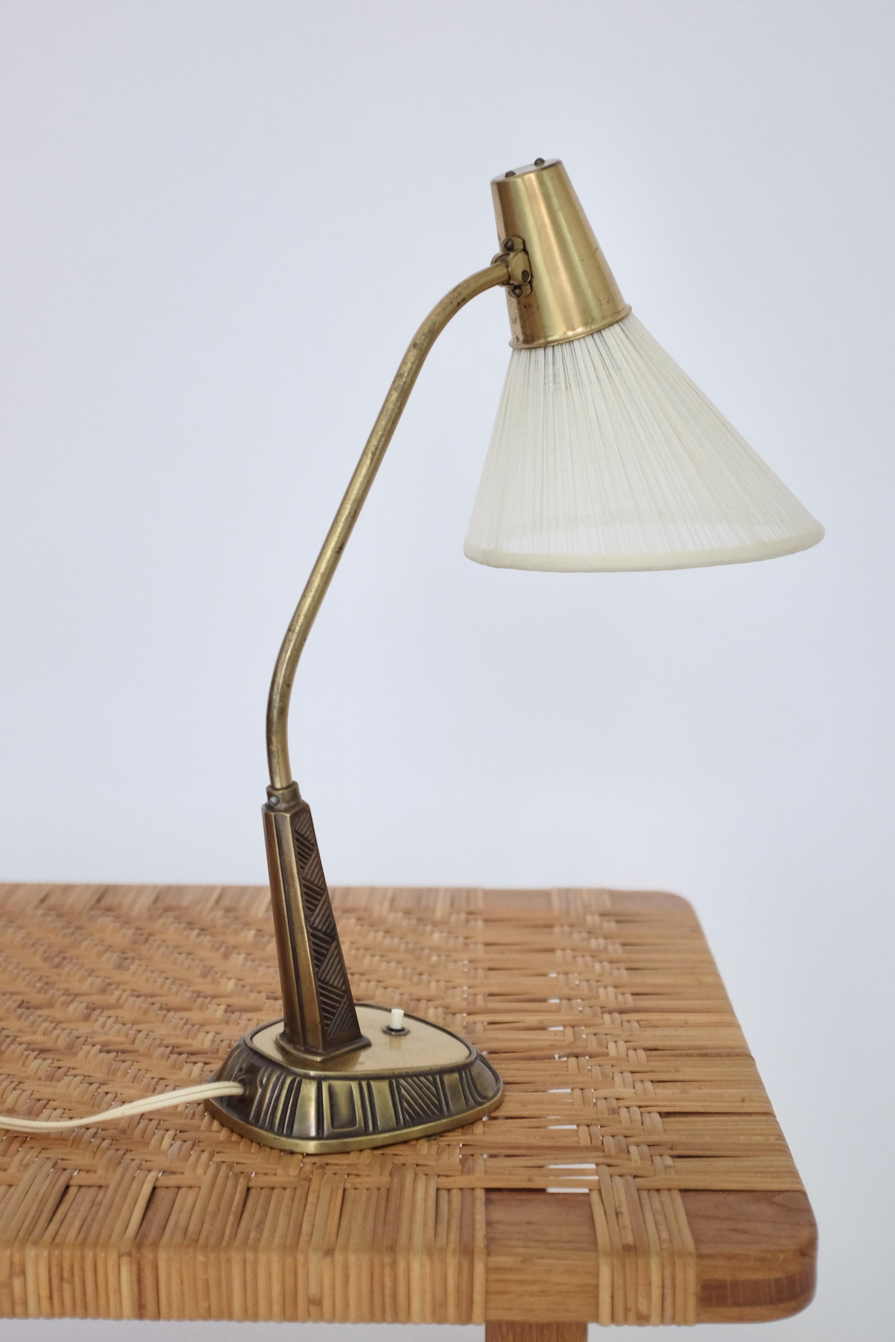 Beautiful 1950's brass table lamp Model E1139 by Sonja Katzin for ASEA. Carved striped pattern on the lamp foot with curved arm och new lampshade in original design. Age appropriate wear to the brass. Overall in a very good condition. 

Sonja