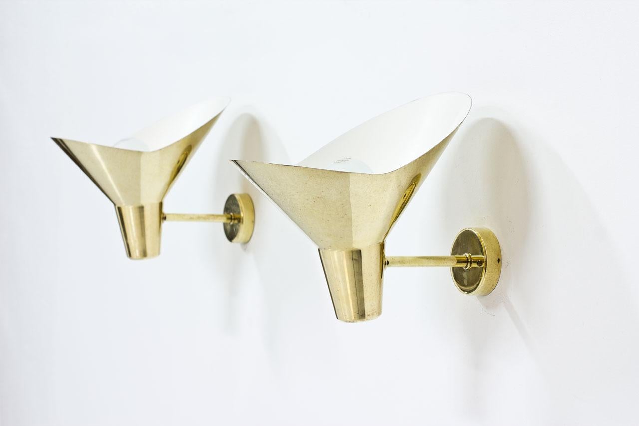 Pair of wall lamps designed by Hans Bergström in 1947. Manufactured by Ateljé Lyktan in Sweden, circa 1950. Polished brass, white enameled inside.