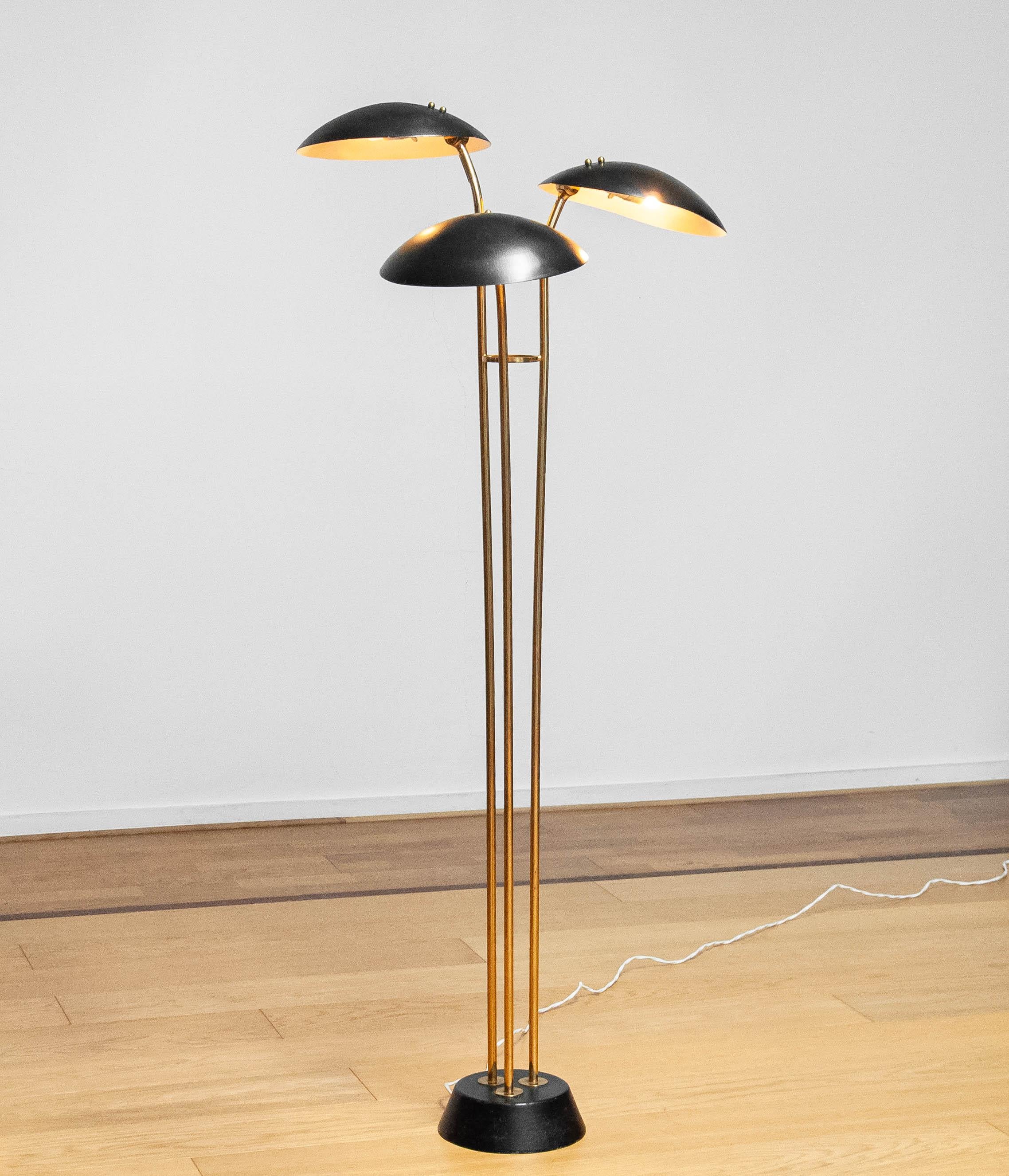 Beautiful and very rare brass floor lamp with three black lacquered metal scale shades ( Model: 74585 ) made by the Malmström brothers for Bröderna Malmströms metallvarufabrik in Malmö in Sweden in the 1950s. 
The elegant shape and design makes this