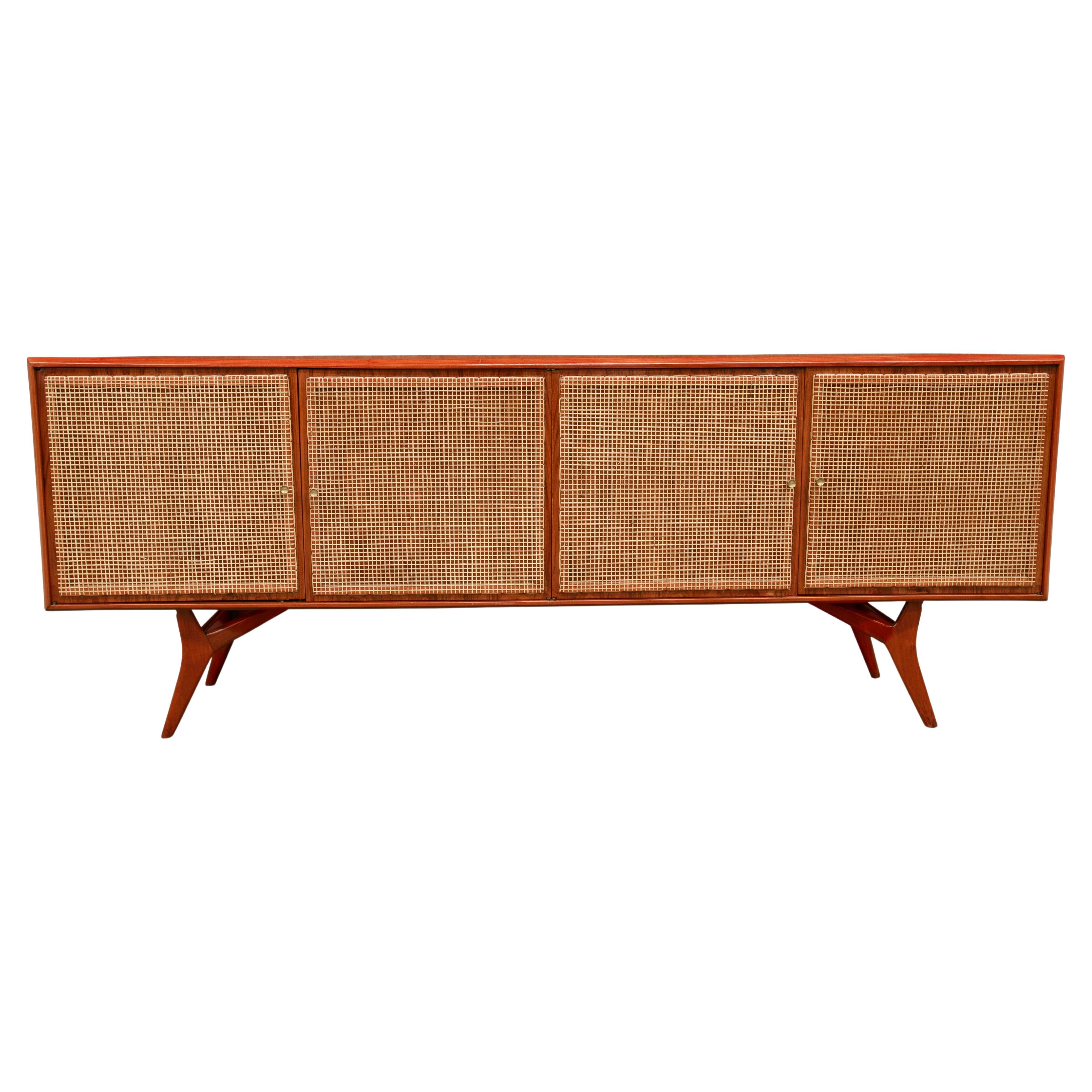 Available today, this Brazilian modern credenza, designed by Forma in the 1950’s, is a true masterpiece! The frame of the credenza is made with caviuna hardwood and the outside of the four doors have a straw weaving. Inside the four doors are