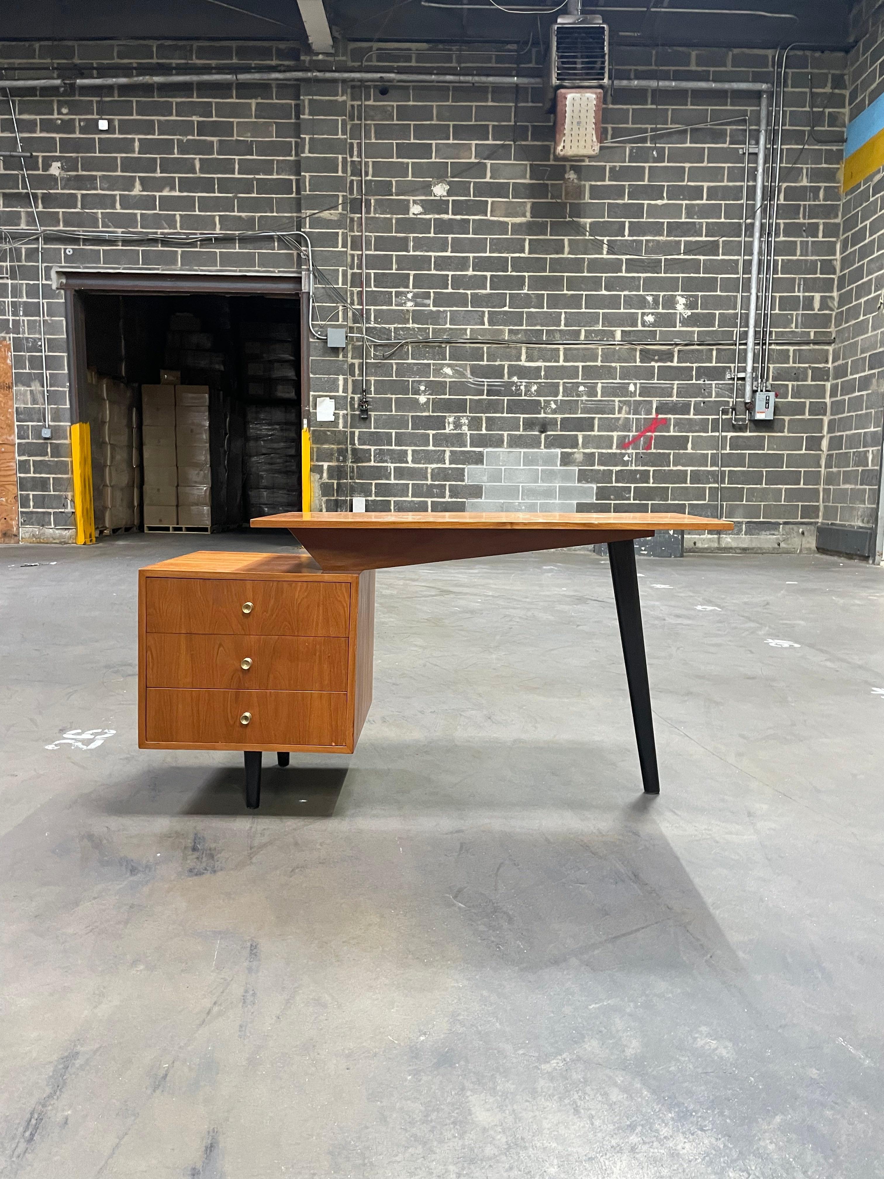 Available today, this mid-century Brazilian modern desk, designed by Moveis Fratte in the fifties, is absolutely magnificent! This desk is made with naval plywood and features three drawers with brass finishes and has three ebonized toothpick legs.