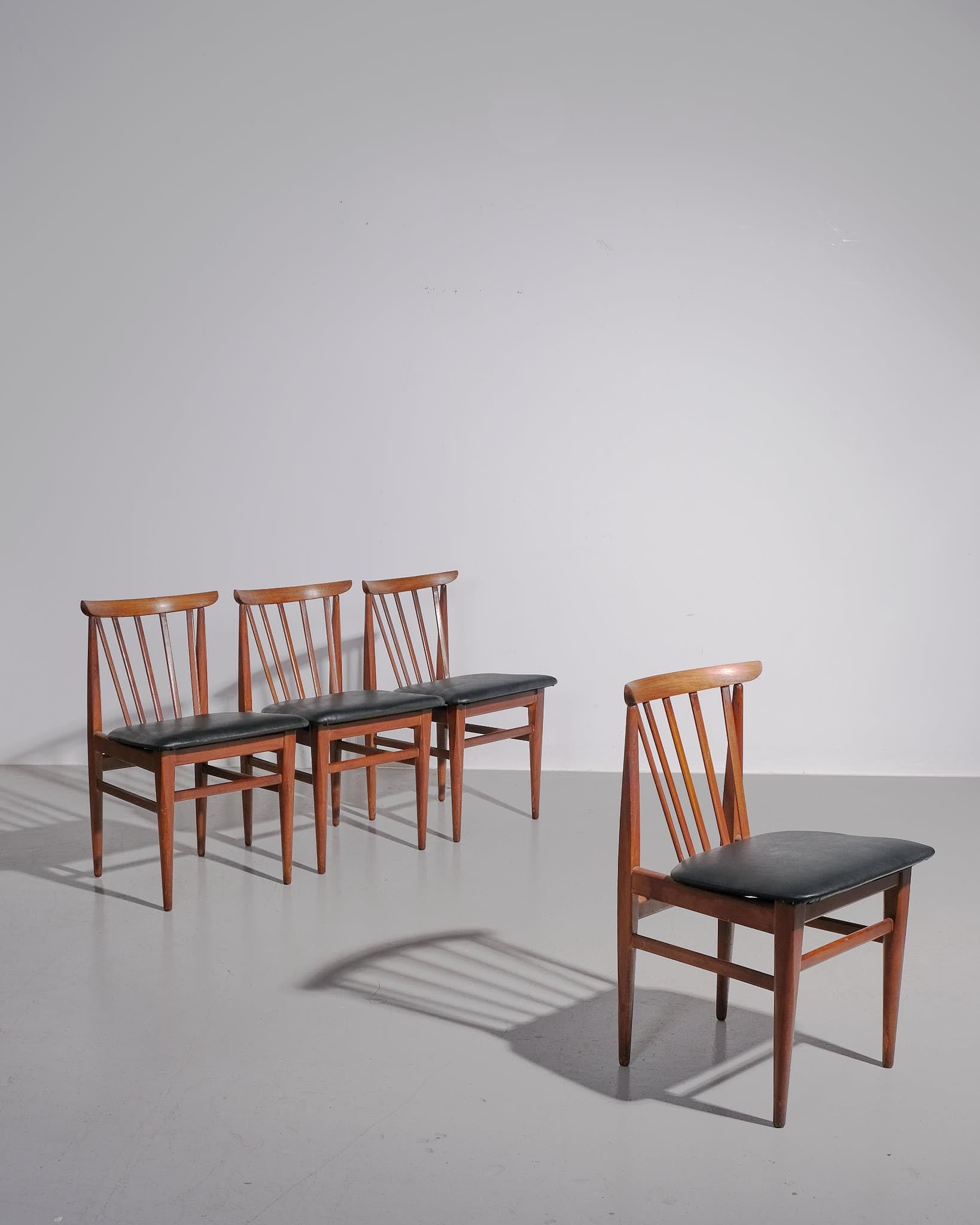 Un set di quattro sedie da pranzo inglesi degli anni '50, costruite in teak massiccio con sedute in pelle imbottite. Il design è caratterizzato da uno schienale leggermente curvo per un supporto ergonomico, gambe dritte e affusolate e una struttura