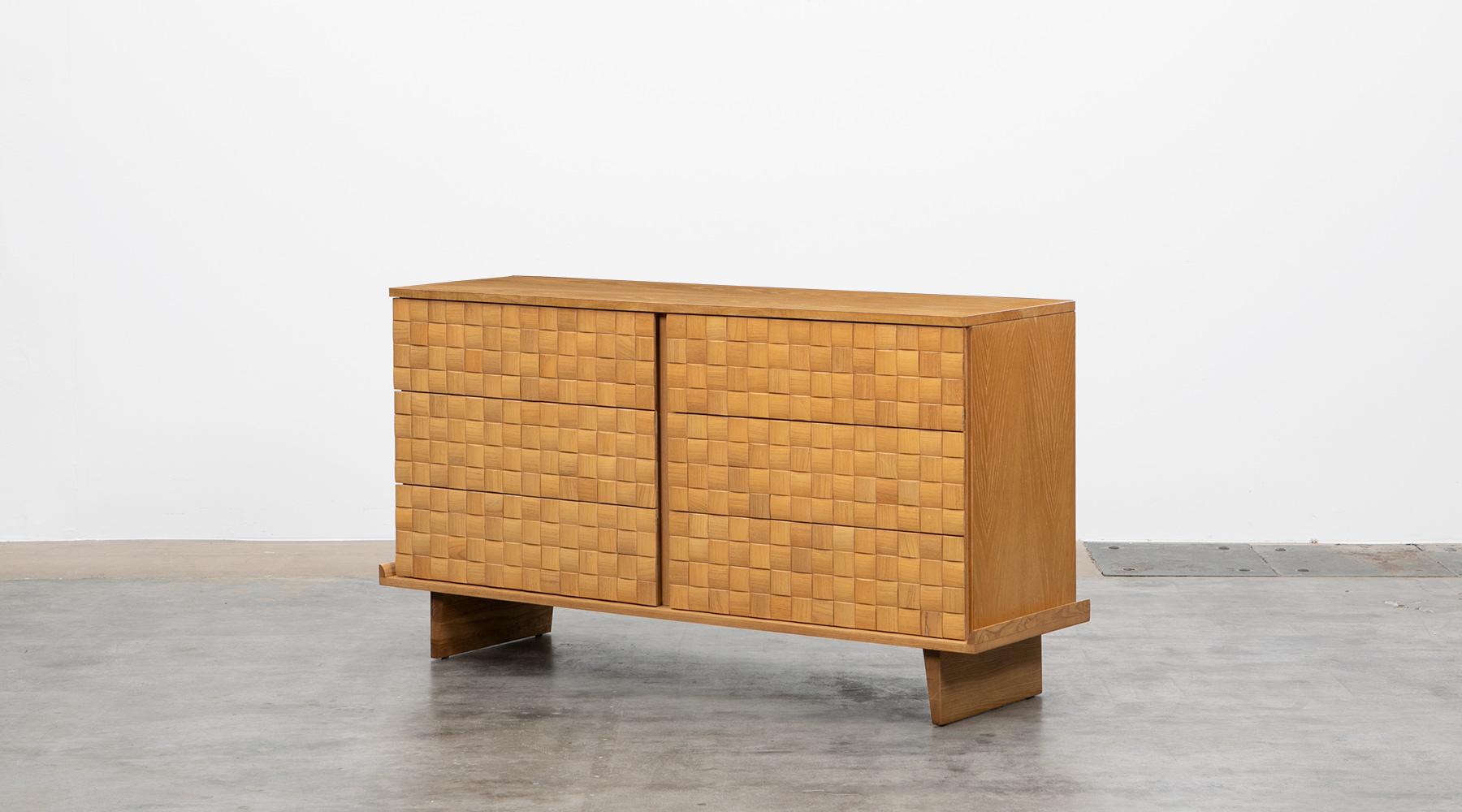 Handsome ash cabinet designed by Paul Laszlo features six of his basket weave drawer fronts and modern shaped legs. The sideboard comes in very good original condition, professionally reworked by our workshop. Manufactured by Brown Saltman.

The