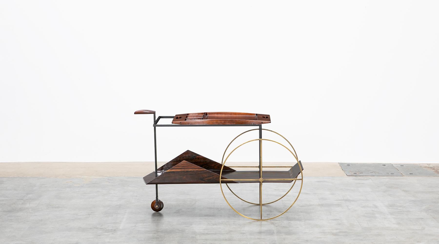 This Brazilian modern classic piece was designed in 1959 by Jorge Zalszupin. The exquisite barcart is made if wood with brass wheels. The top shelf is a removable tray. Noble lines, the essential use of native wood and a combination of impeccable
