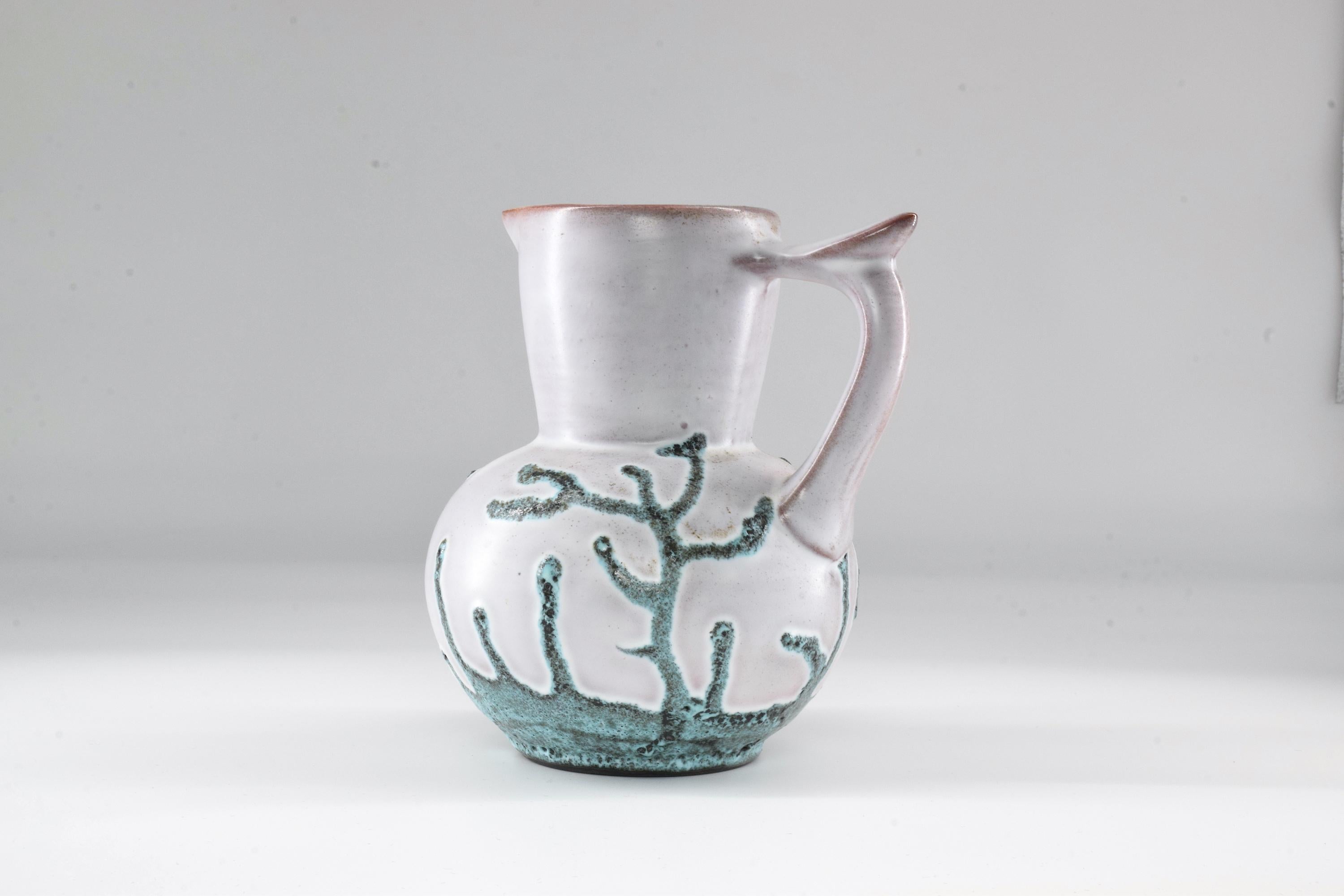 This is an original ceramic pitcher designed by French designer Bruno Dose, for the prestigious Poterie du Breuil. A pretty decorative object for any living area, with its soft pattern made of green coral-like branches and unique handle. Impeccable