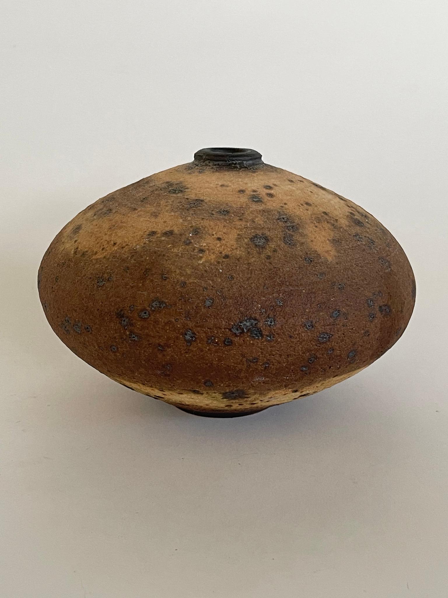 1950's Brutalist Vessel has a unique color way with ash burn like markings through out the piece. The handmade vessel/vase has an ellipsoidal shape with a small opening. 
 ?
Dimensions: 
8