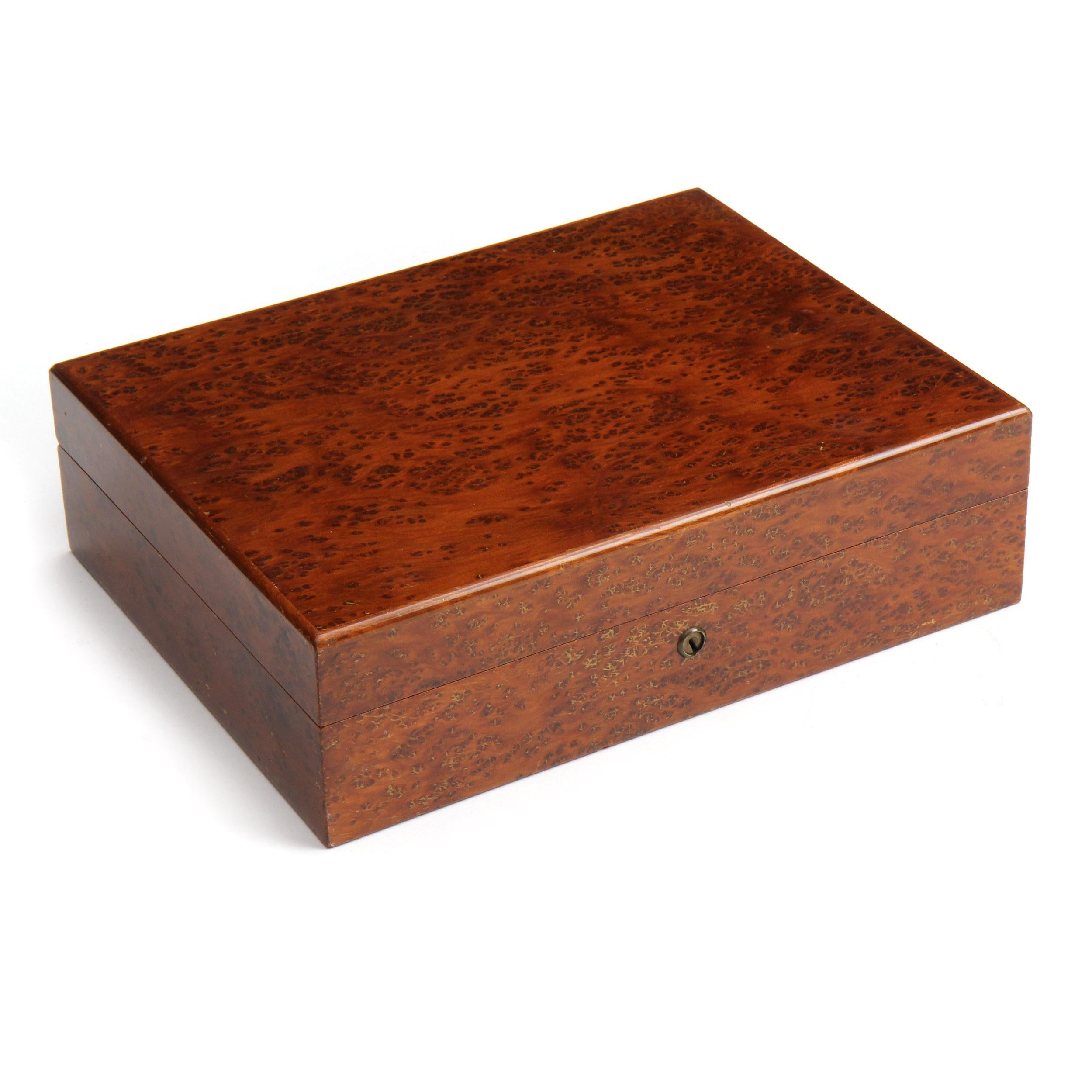 A humidor made of warmly toned burled maple with a cedar and glass interior.