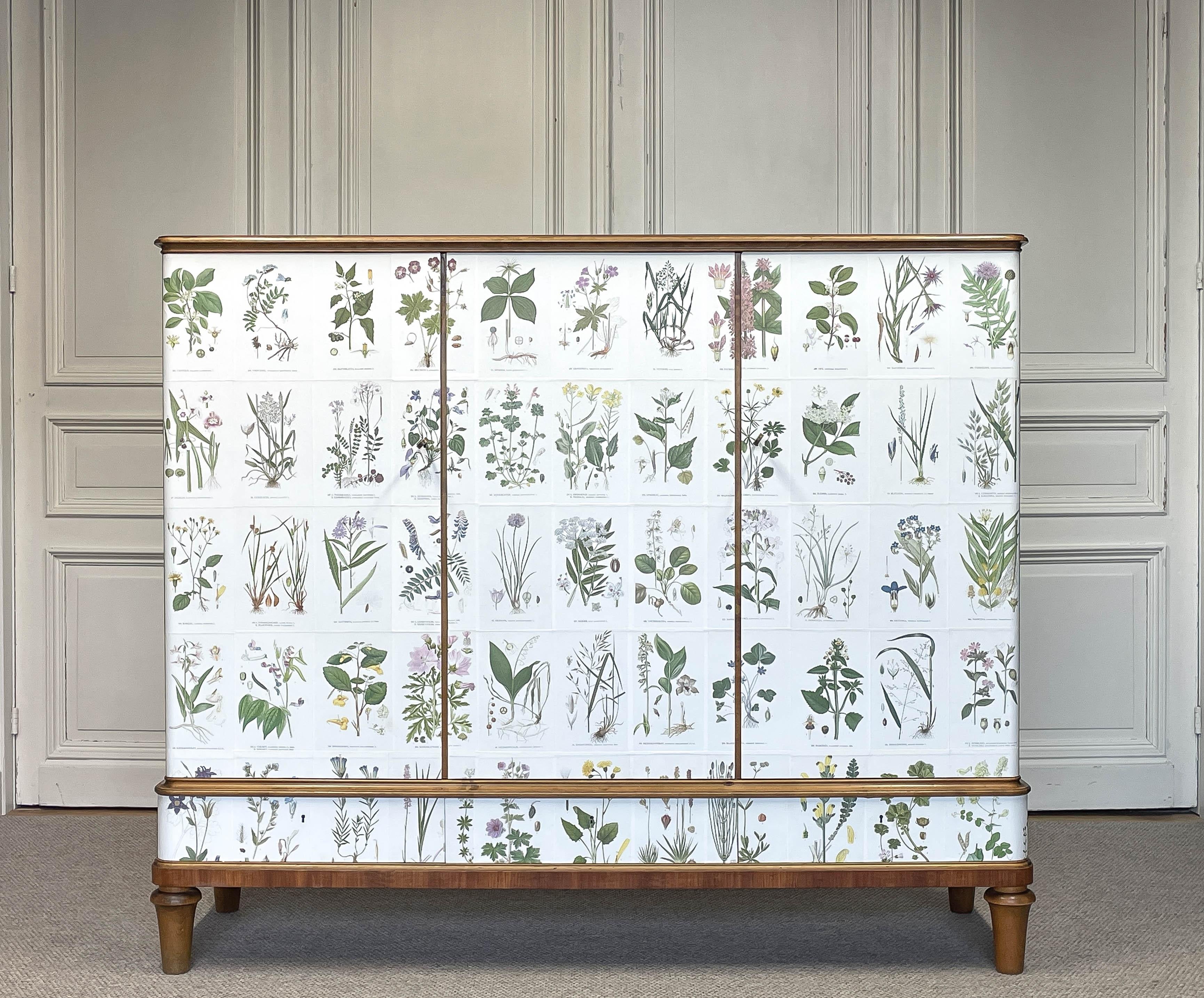 A striking 1950s teak and beech cabinet or buffet, richly decorated with illustrations from Nordens Flora by Carl Axel Magnus Lindman, Sweden. The botanical prints give the piece a lively, artistic character reminiscent of Josef Frank’s design