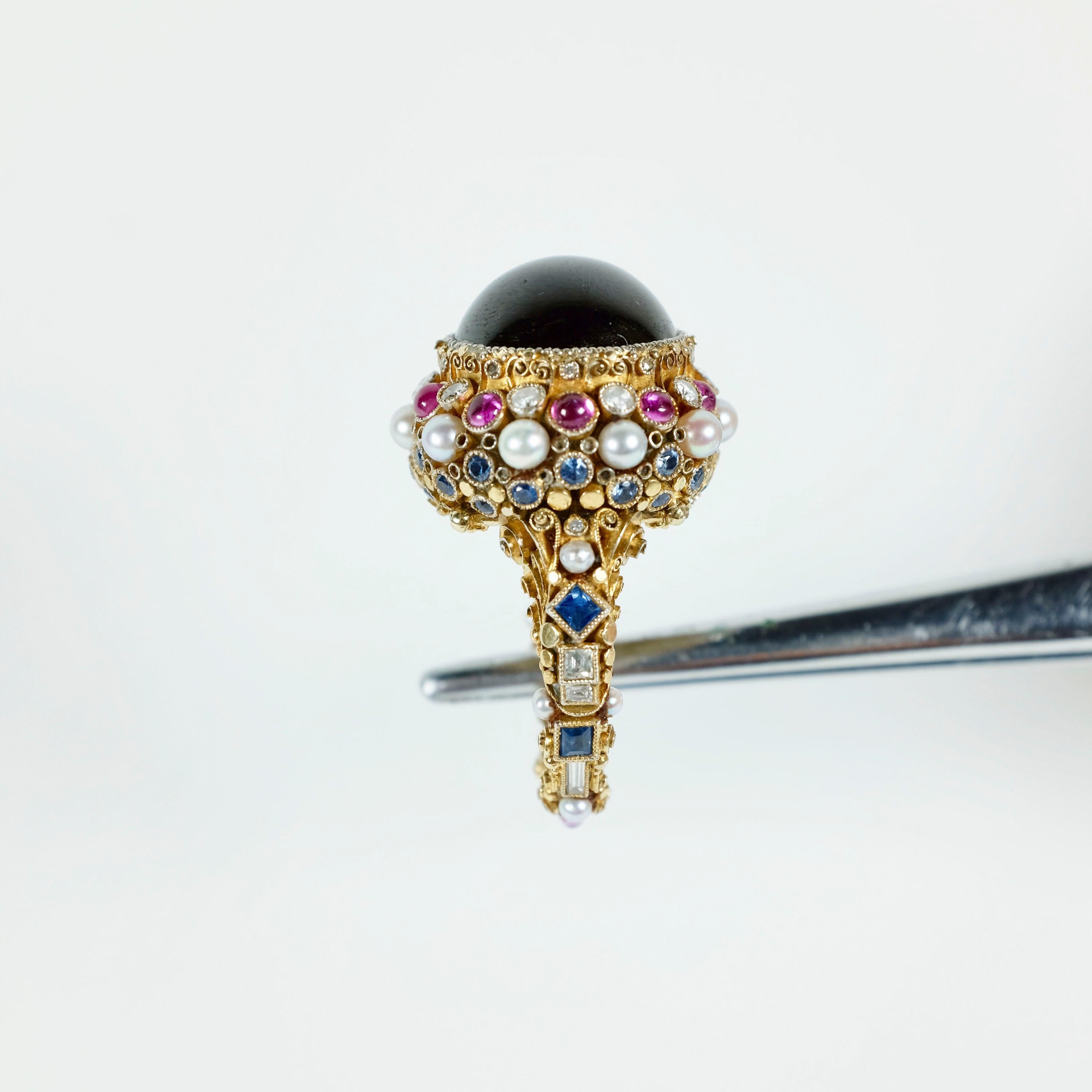 Ring by Elmar Seidler, Set with a cabochon garnet, the shoulders and mount set with brilliant-, step-cut, baguette and rose diamonds, seed pearls, circular and square cut sapphires and cabochon rubies, the underside of the mount opens to reveal a