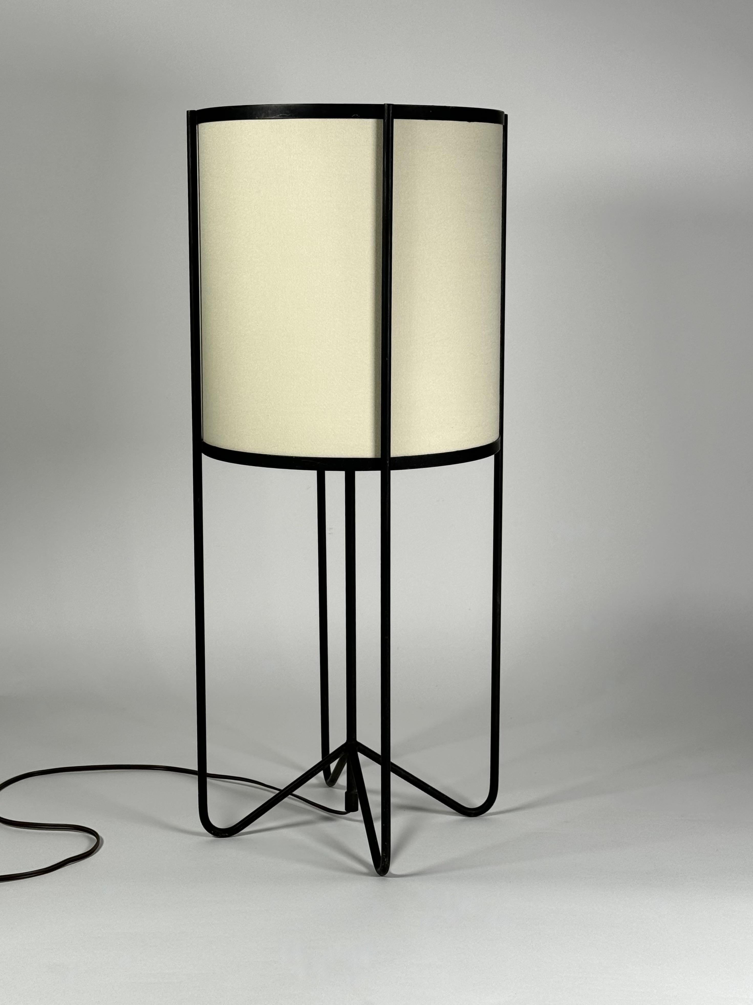 Wrought iron and linen table lamp which embodies the design ethos of the 1950s California Design Lifestyle viewpoint, this design with curved leges and drum shade evokes the connection with the Pacific Rim influence of Japanese culture in Modernist
