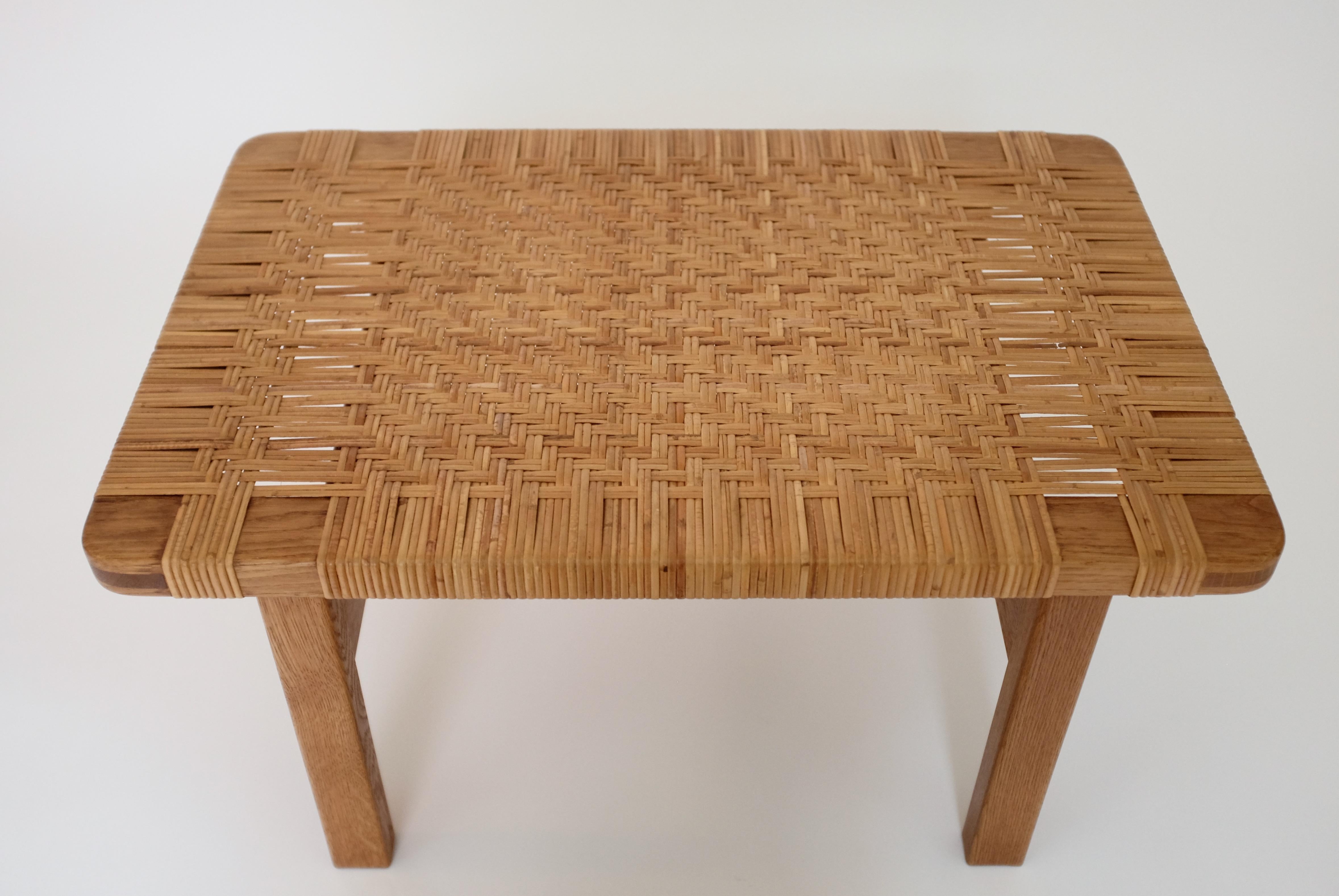 Iconic cane and oak side table by Børge Mogensen for Fredericia Stolefabrik, Denmark. Designed and manufactured in the 1950's it has the classic traits of Børge Mogensen with practical design and beautiful details. Woven cane across the table in a