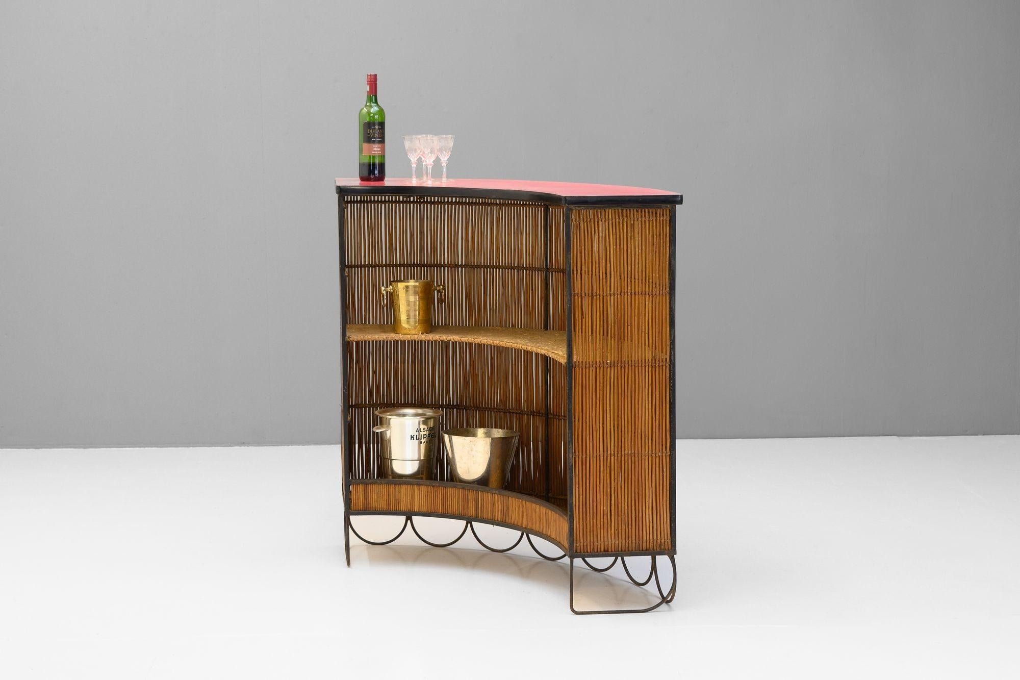 Barra de bar con frente de caña, base decorativa de hierro y encimera original de formica roja. Alrededor de 1950.


Alto 108 cm x Ancho 120 cm x Fondo 47 cm (Ancho de barra 30 cm)