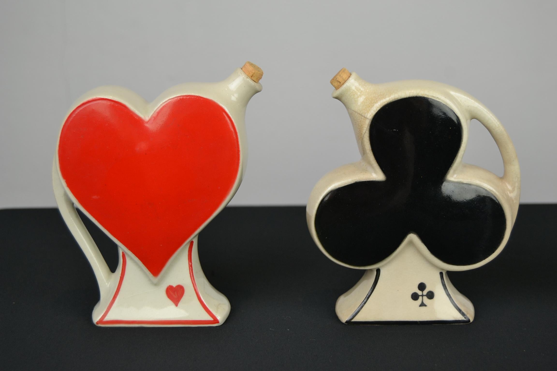 1950s set of 4 liquor bottles in the shape of the red and black playing card symbols or pips: clubs, diamonds, hearts and spades. This porcelain revol bottles were made for the Distillerie Benoit Serres Toulouse France in 1952. Each ceramic decanter