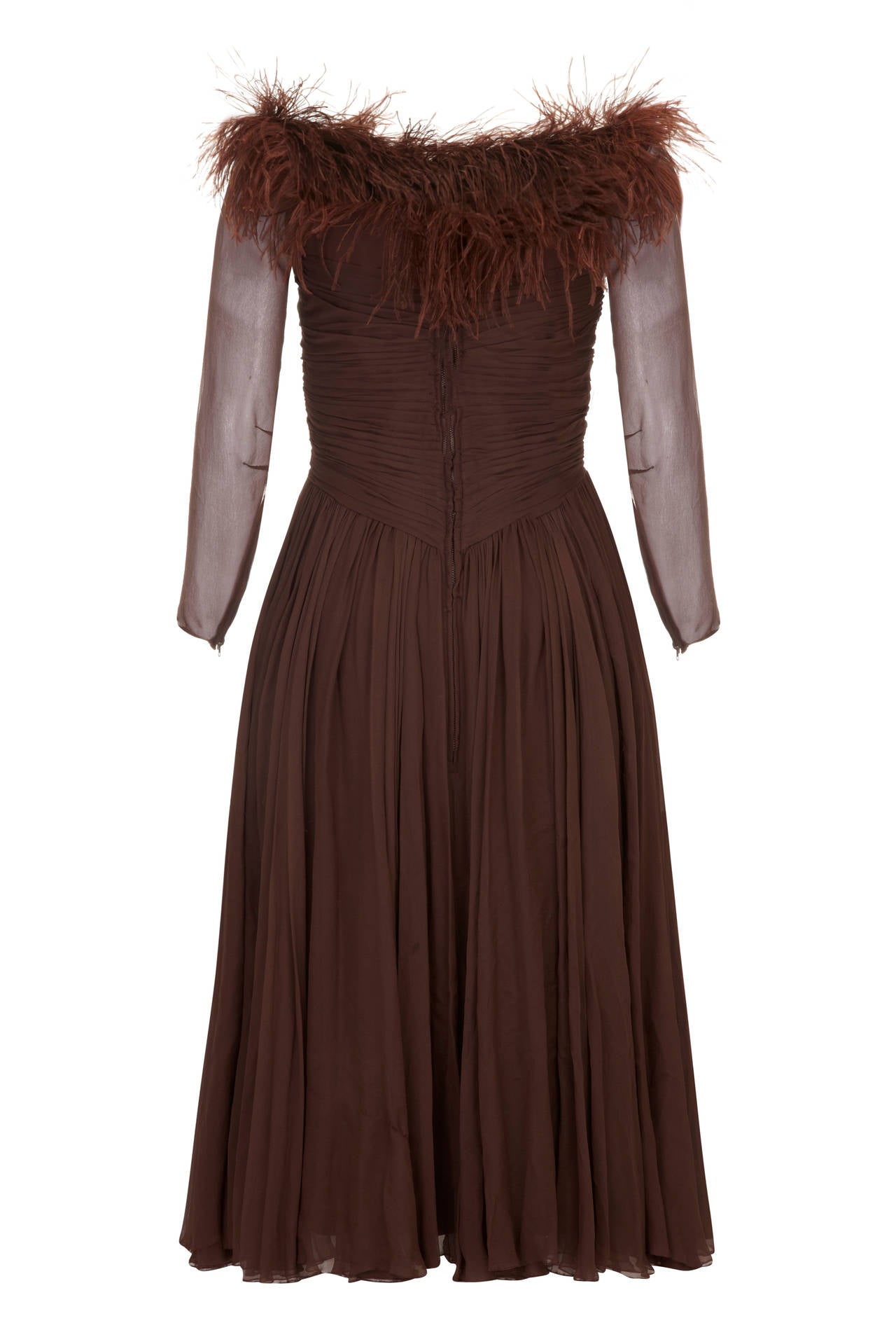 This gorgeous chestnut brown silk chiffon dress is from American boutique label Cardinal. The chiffon bodice is gathered into pleats with tiny covered buttons down the centre front and the sheer 3/4/ length sleeves taper at the wrists with zipper