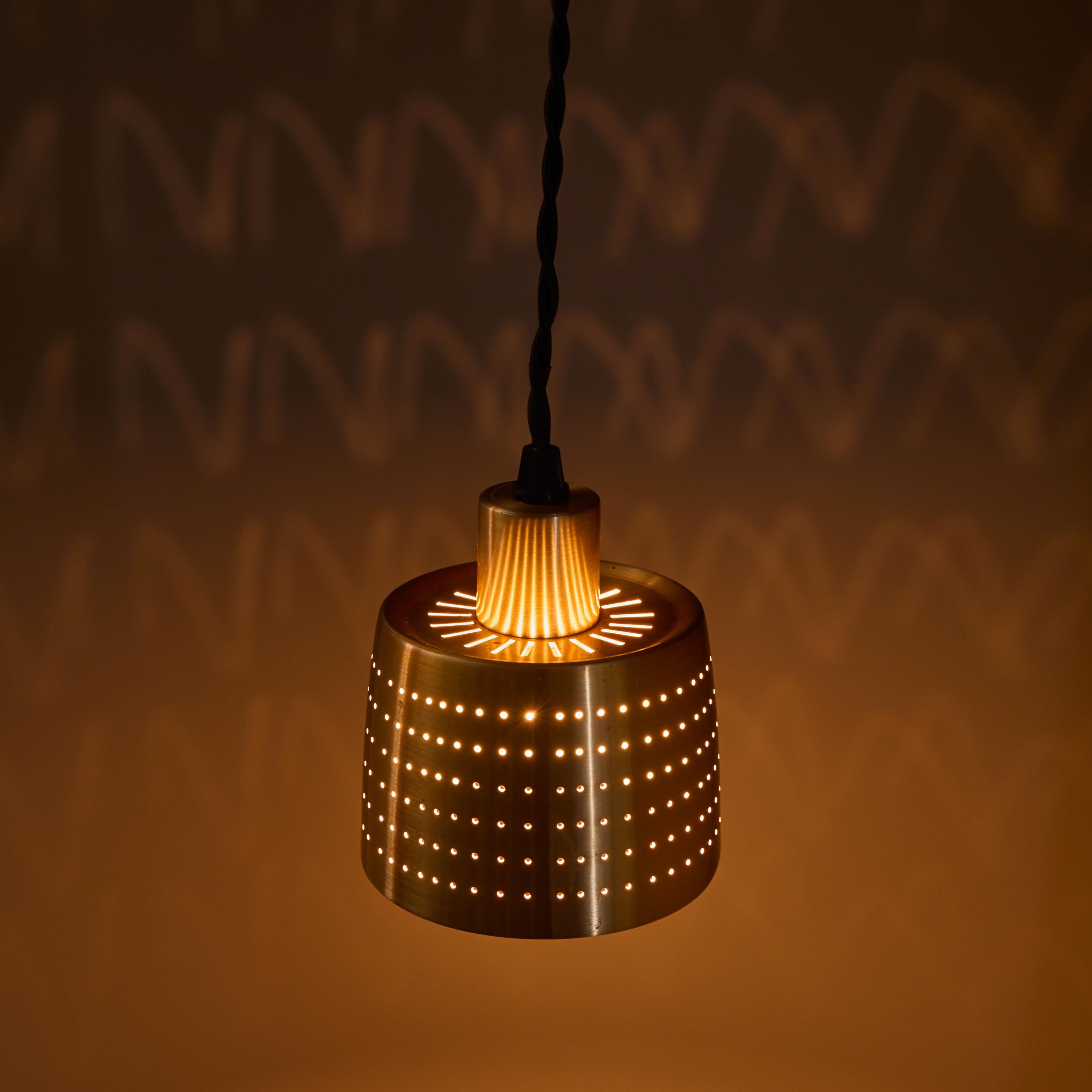 1950s Carl Thore Perforated Brass Pendant

Executed in perforated brassed metal with an attractive patina, this sculptural pendant lamp is highly characteristic of quintessential Swedish design of the midcentury era. Unmarked. The perforated shade