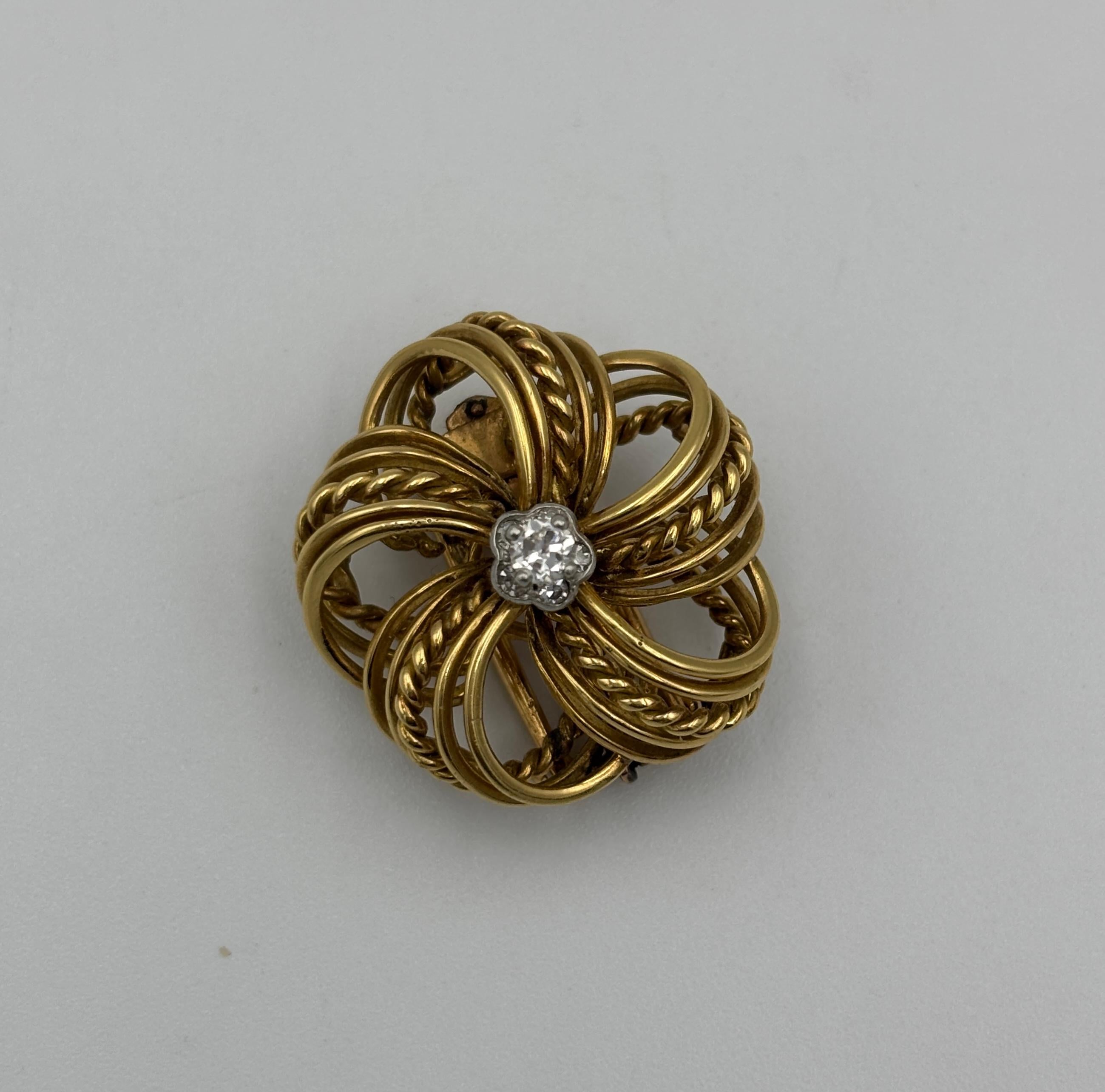 Dies ist eine charmante kleine Brosche von Cartier Paris aus der Zeit um 1950. Er ist aus 18 Karat Gold gefertigt und hat einen zentralen Diamanten von 0,1 Karat, der von 5 kleineren Diamanten von insgesamt 0,1 Karat akzentuiert wird. Sie ist