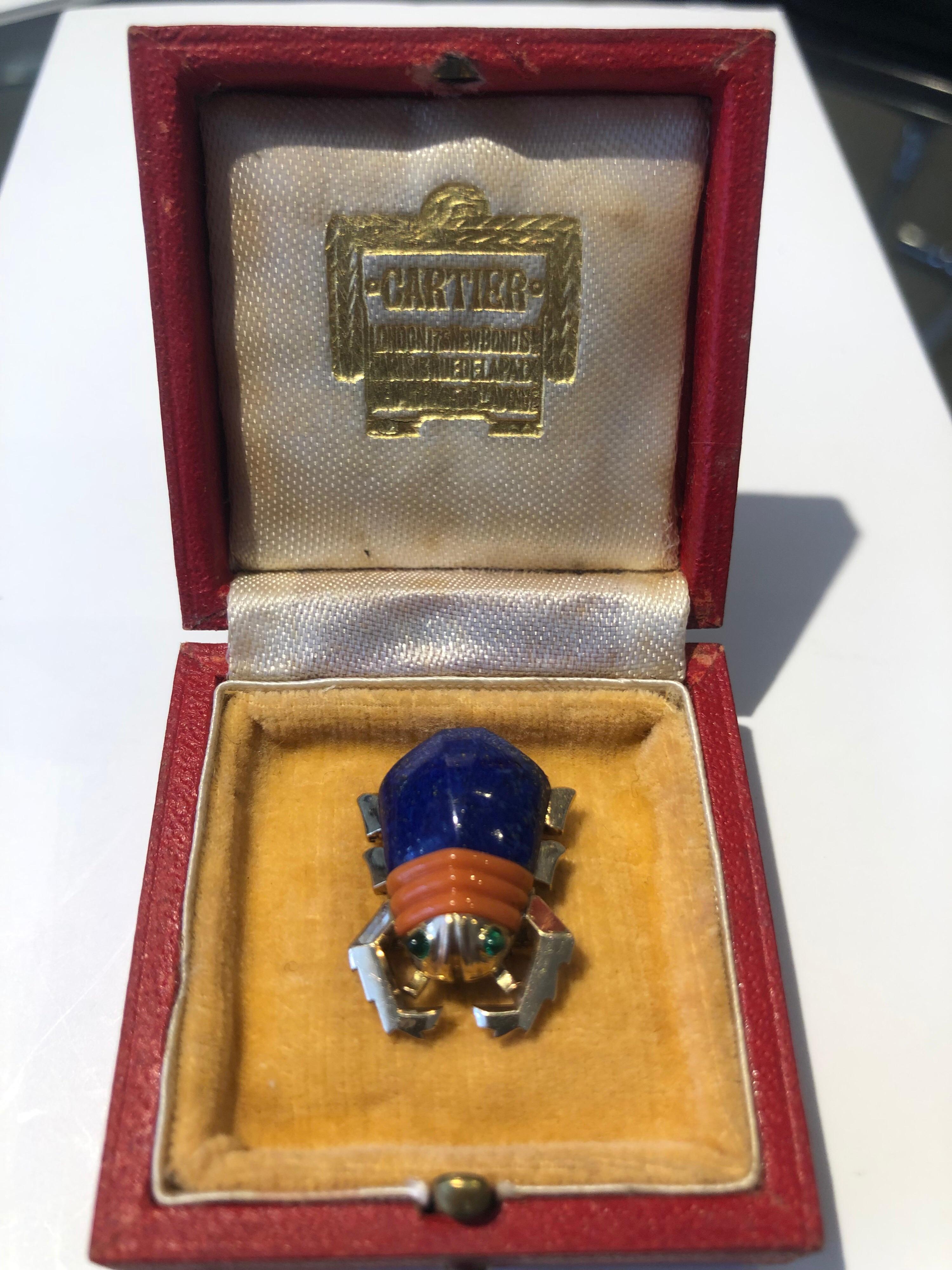 A 1950’s Cartier Lapis Lazuli and Coral Beetle Brooch. This rare and charming brooch has a Lapis Lazuli and carved Coral body and eyes which are set with small cabochon emeralds.
The brooch is signed Cartier London and numbered 4390
The brooch