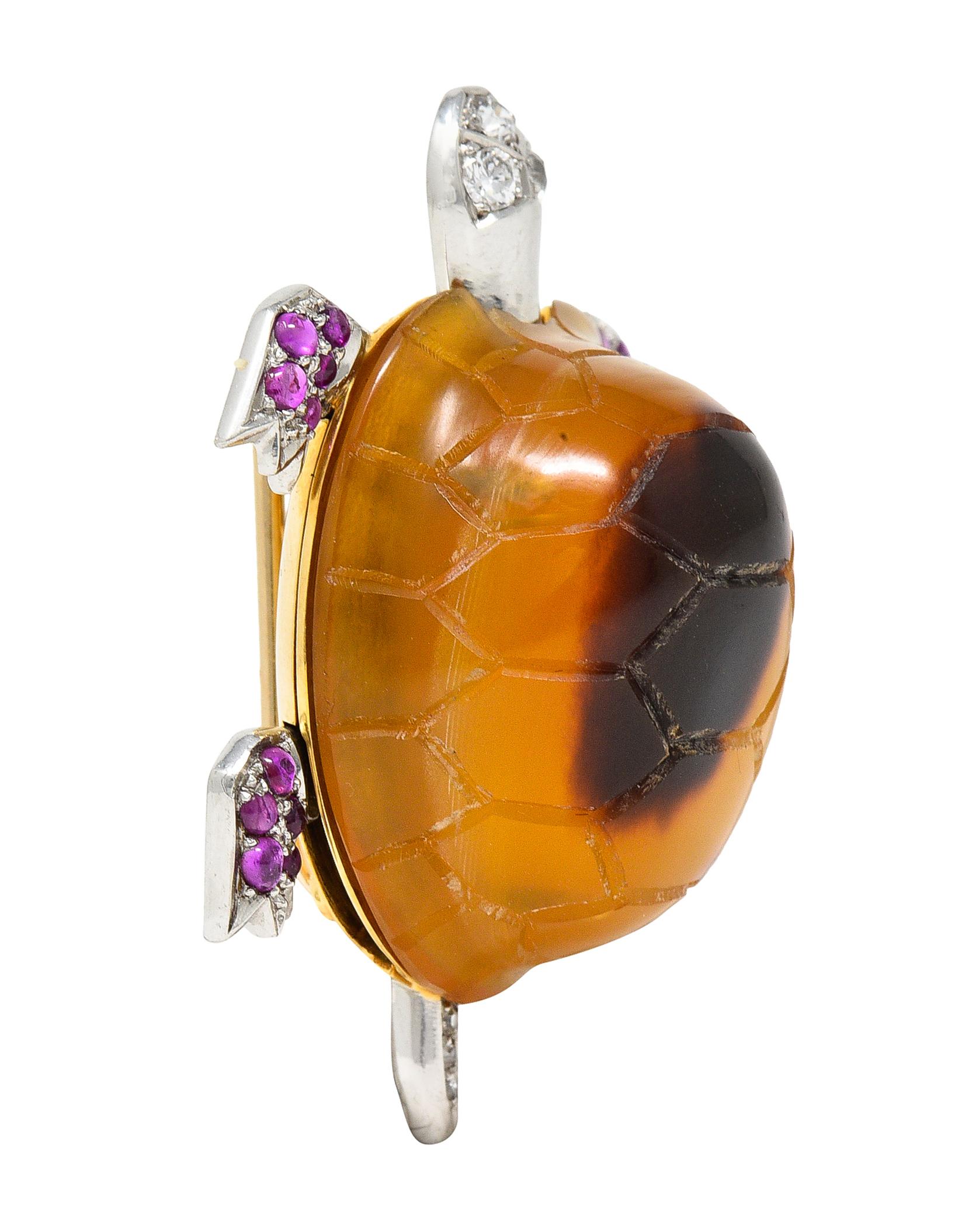 Brooch is designed as a turtle with articulated platinum limbs

Shell is highly domed and comprised of carved tortoise shell

Translucent honey yellow with dark brown spotting

Accented by cabochon rubies and diamonds

Weighing collectively